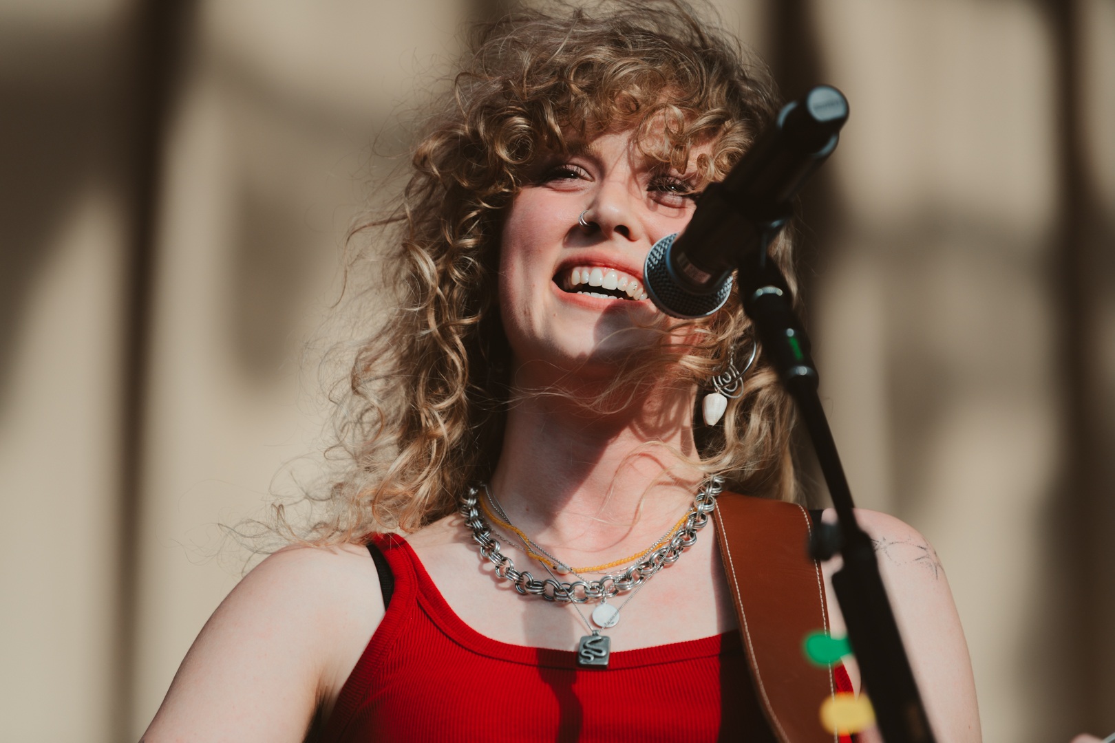 Smiling musician with curly hair performing outdoors