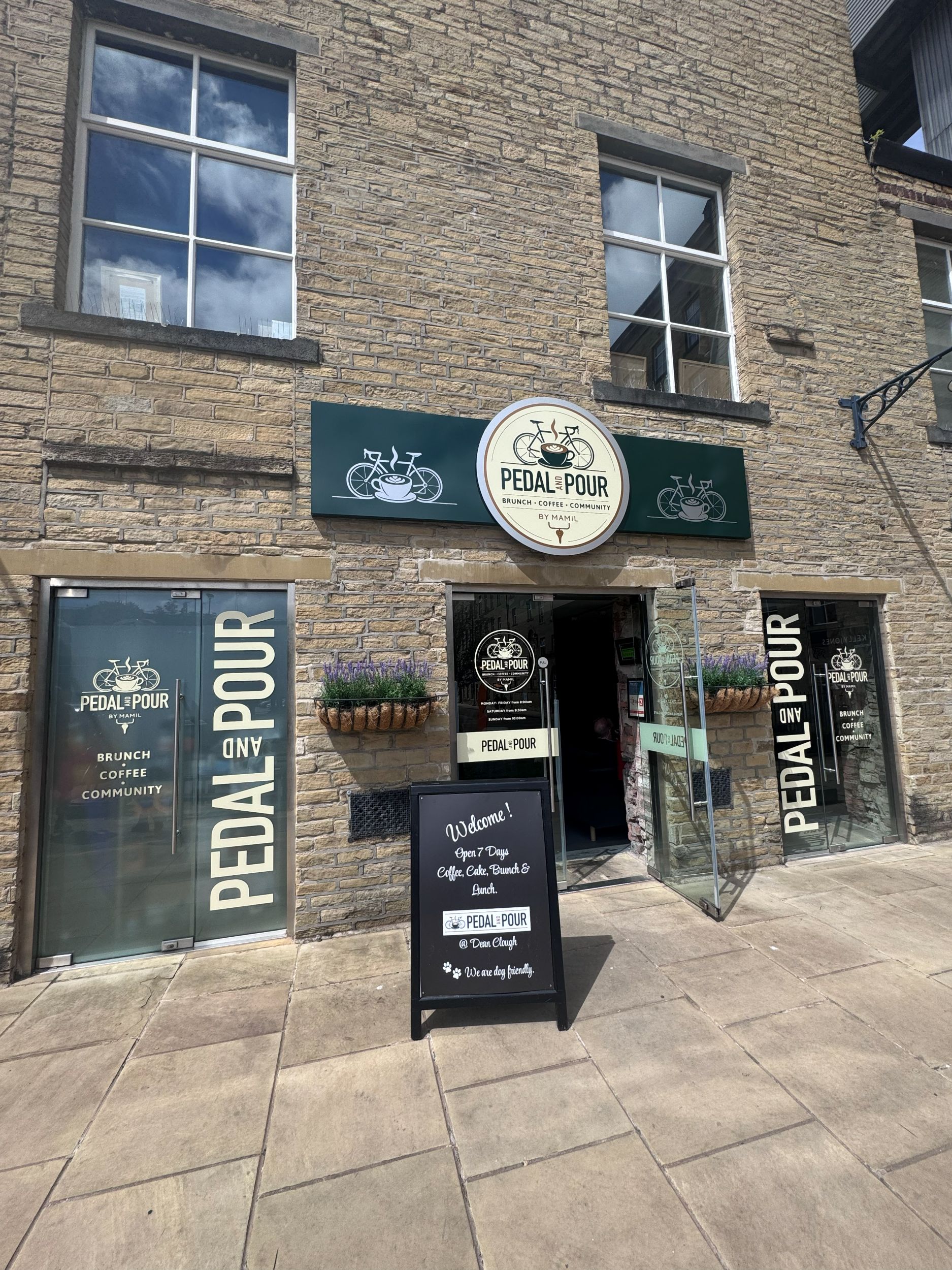 Stone cafe facade with green signage and glass doors