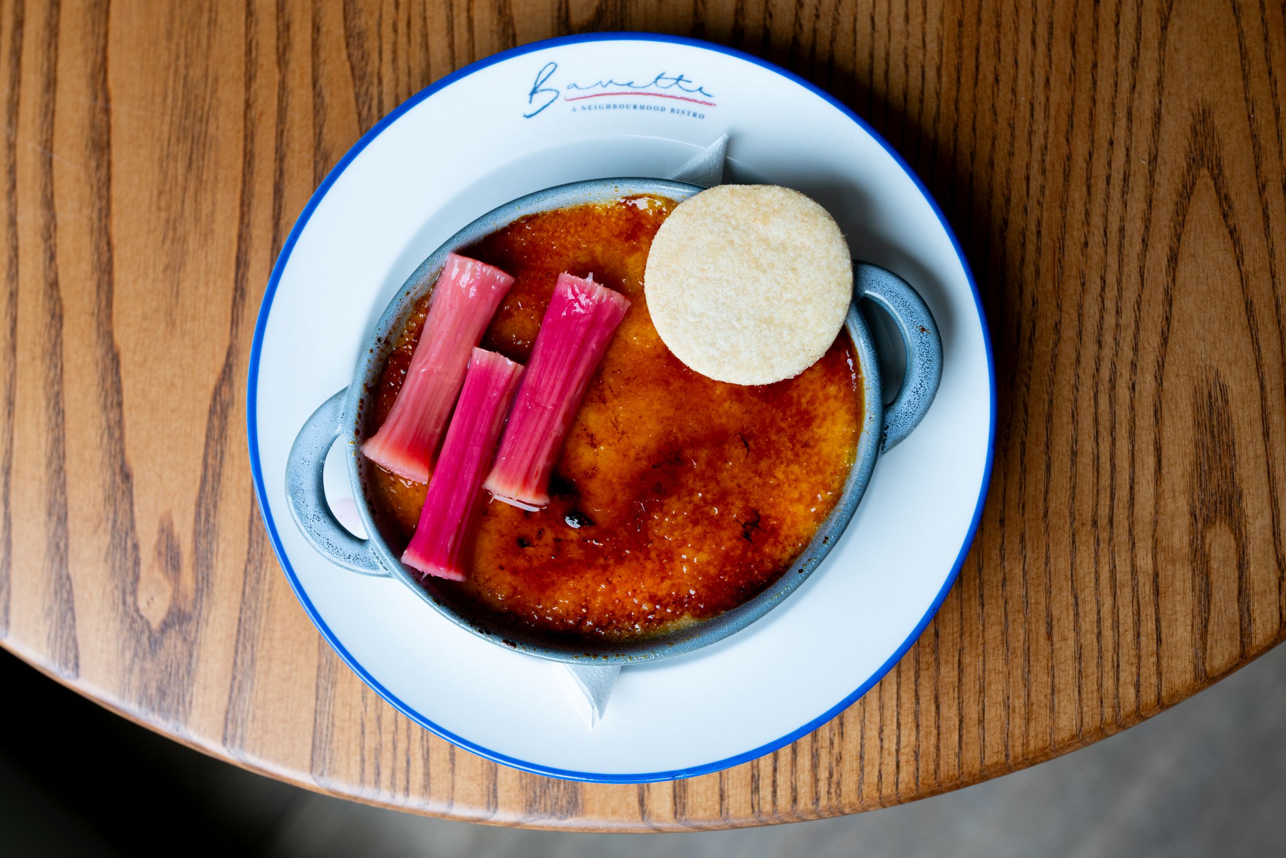 Crème brûlée with rhubarb sticks and shortbread on a plate