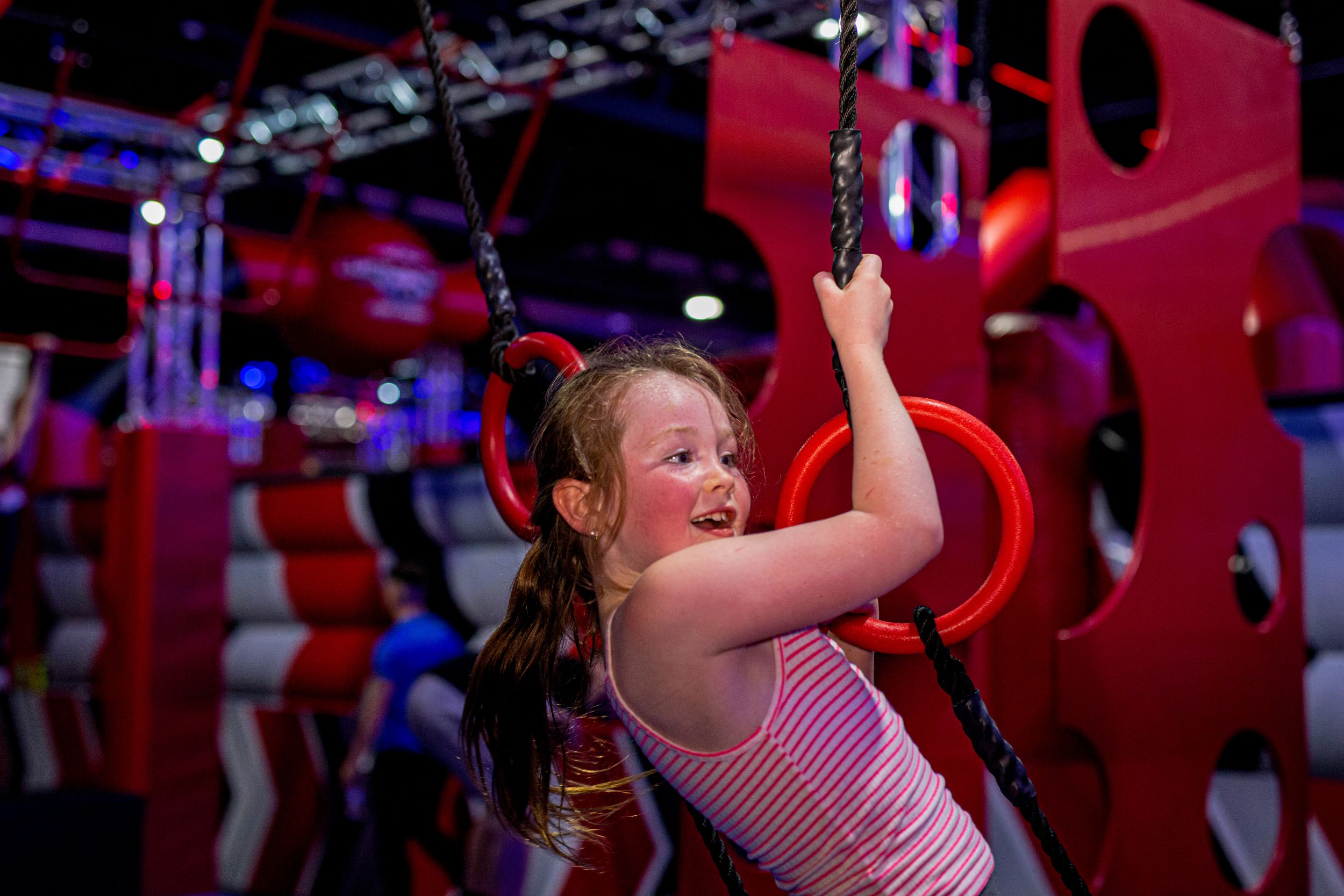Child enjoying obstacle course at indoor adventure park