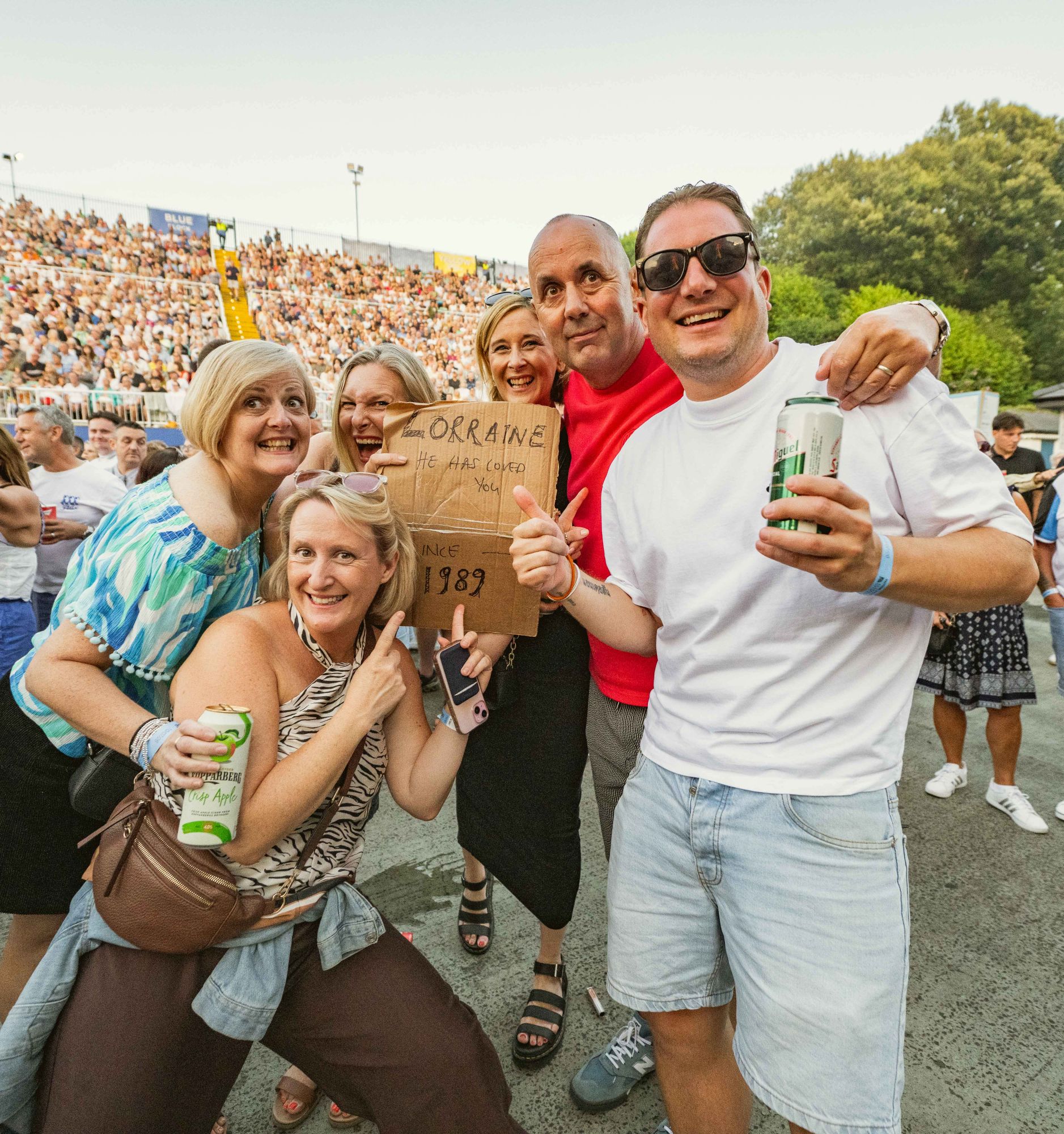 Group of smiling people enjoying a summer festival with drinks