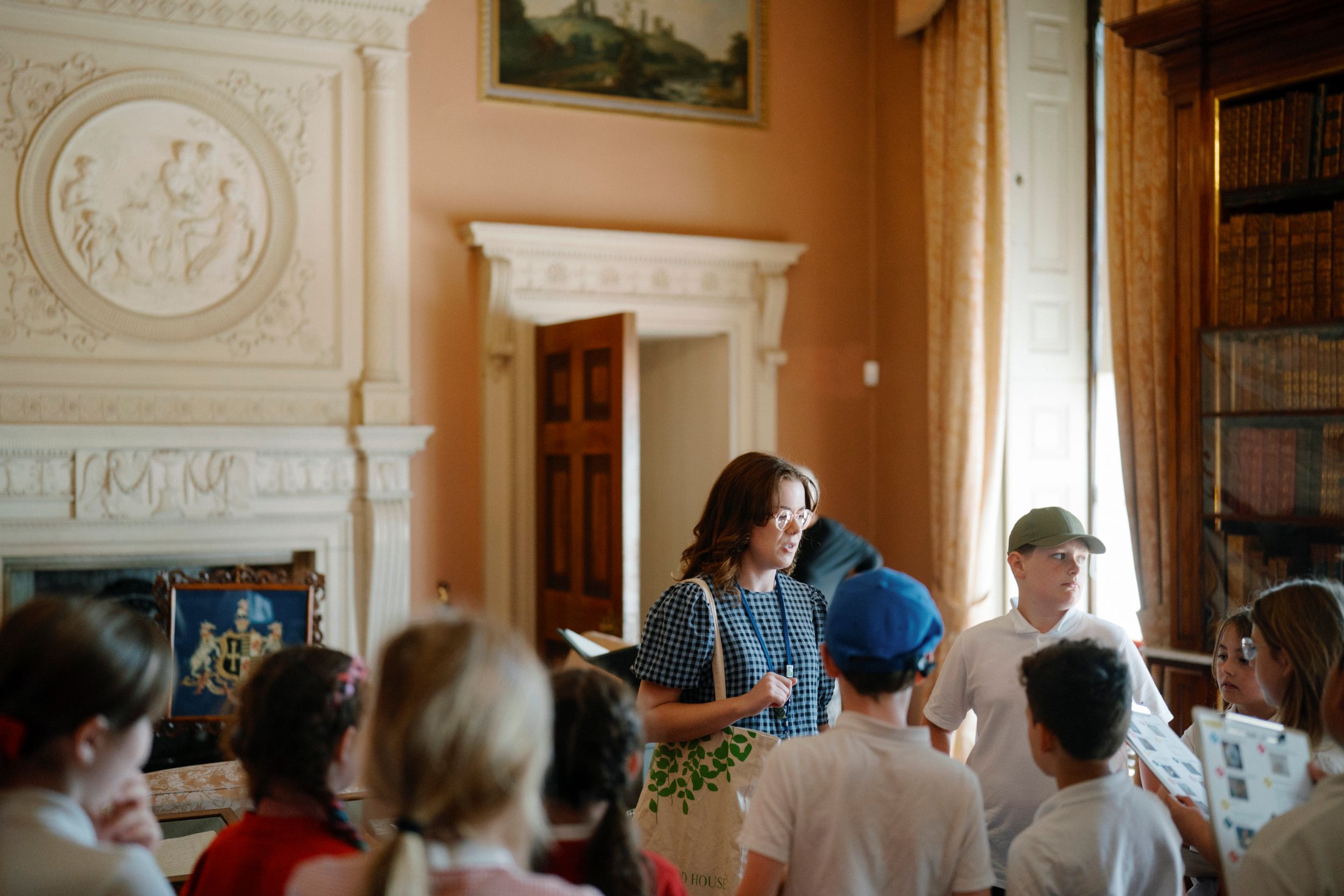 Tour guide explaining history to children in a stately room