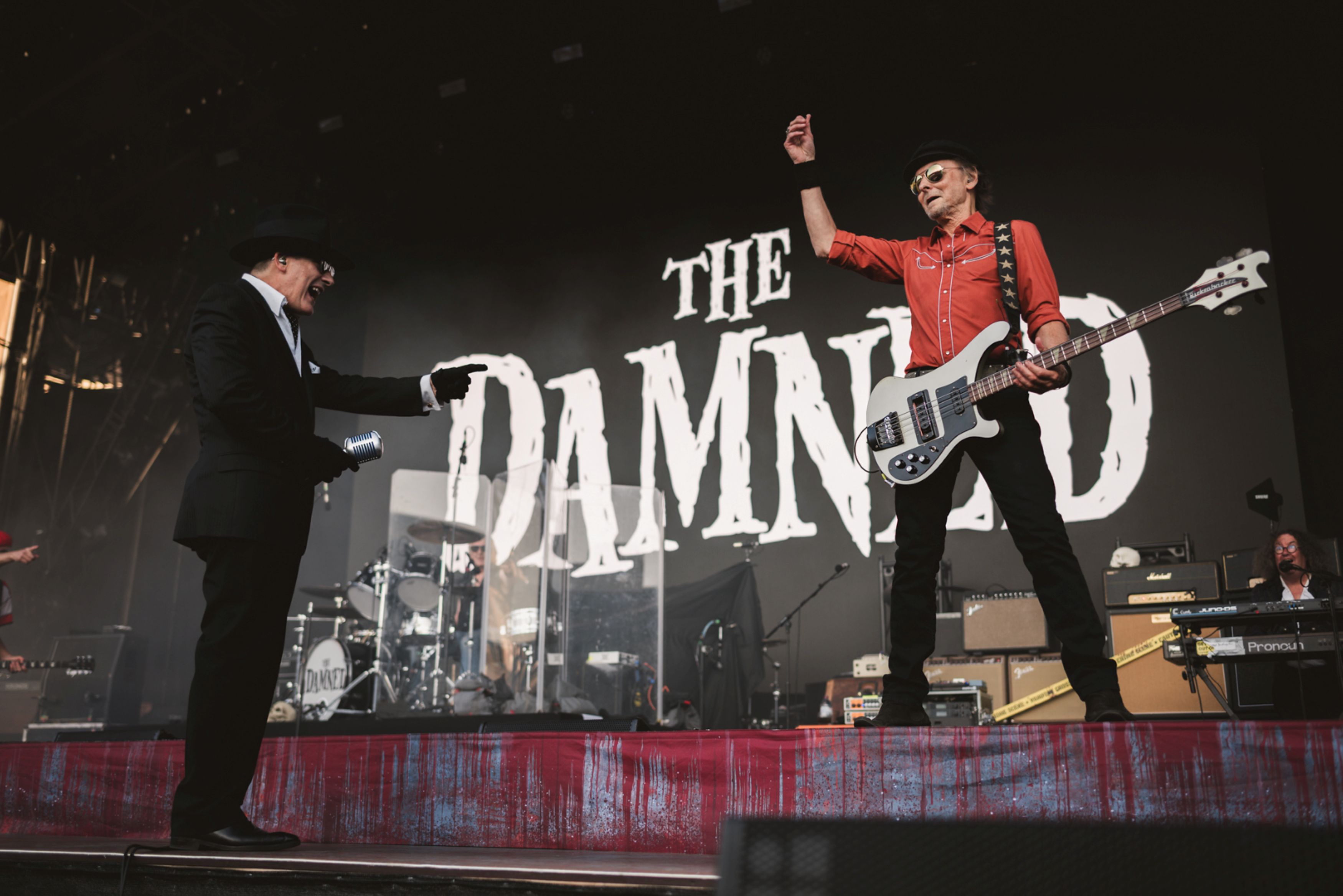 Rock musician on stage playing guitar in front of band logo