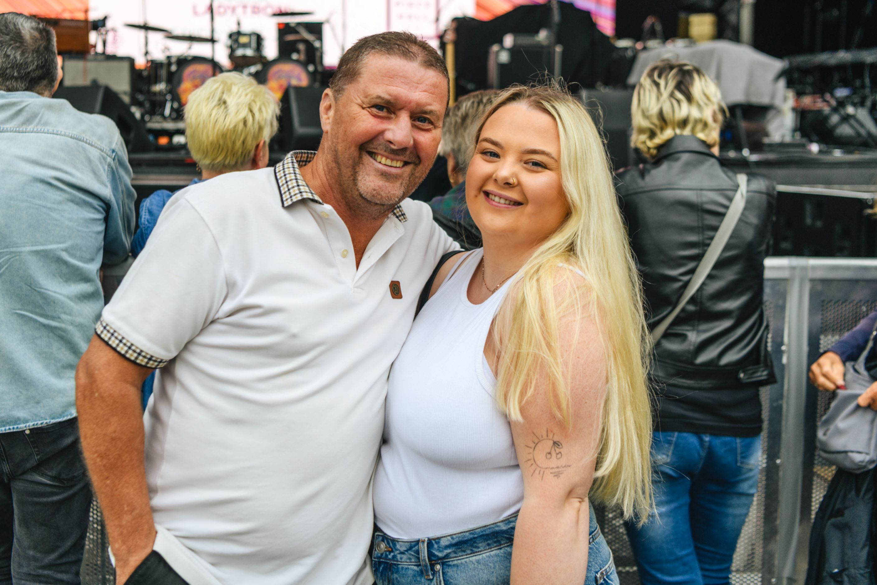 Smiling father and daughter at an outdoor music festival
