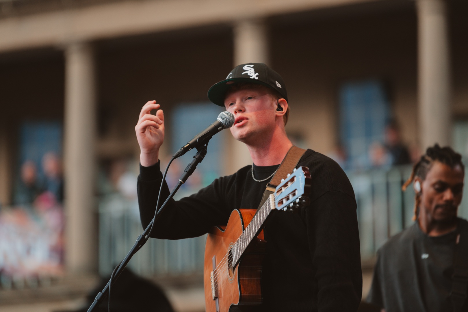 Street musician playing guitar and singing in a lively market