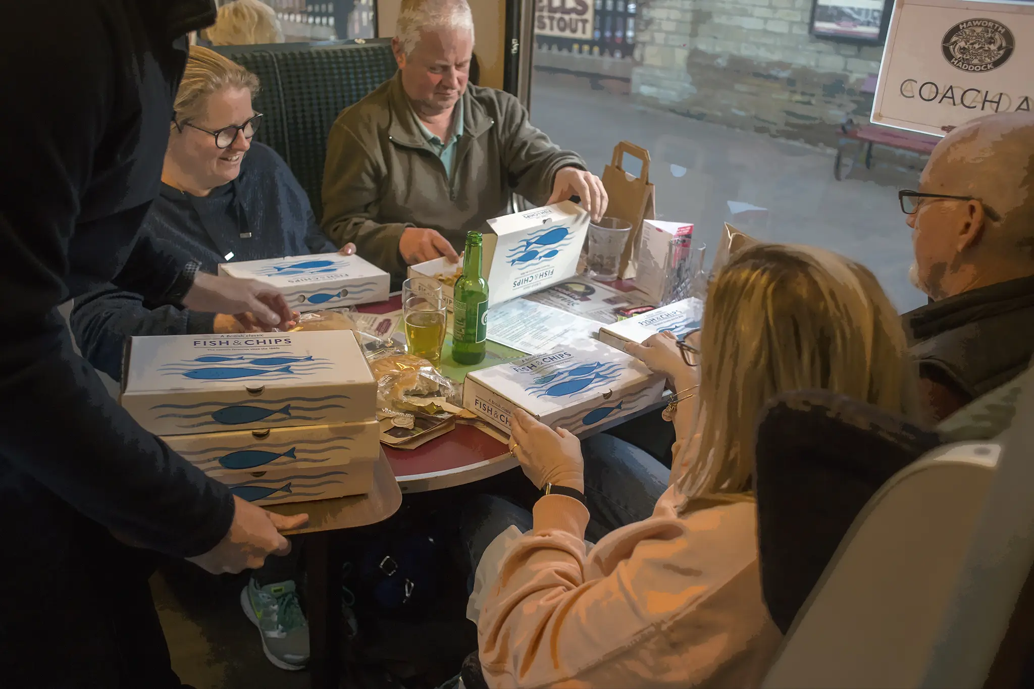 Group of people enjoying fish and chips on a train