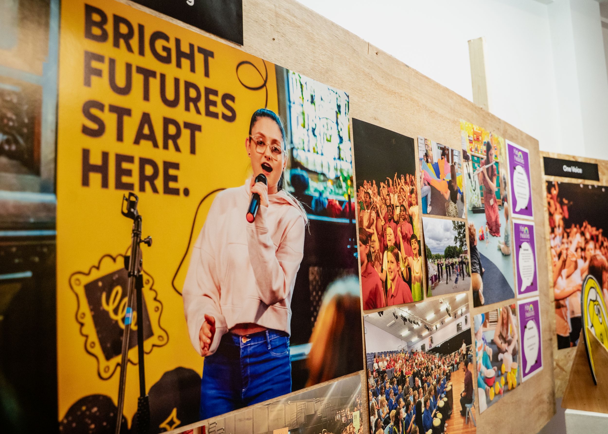 Exhibition wall with vibrant posters and group photos