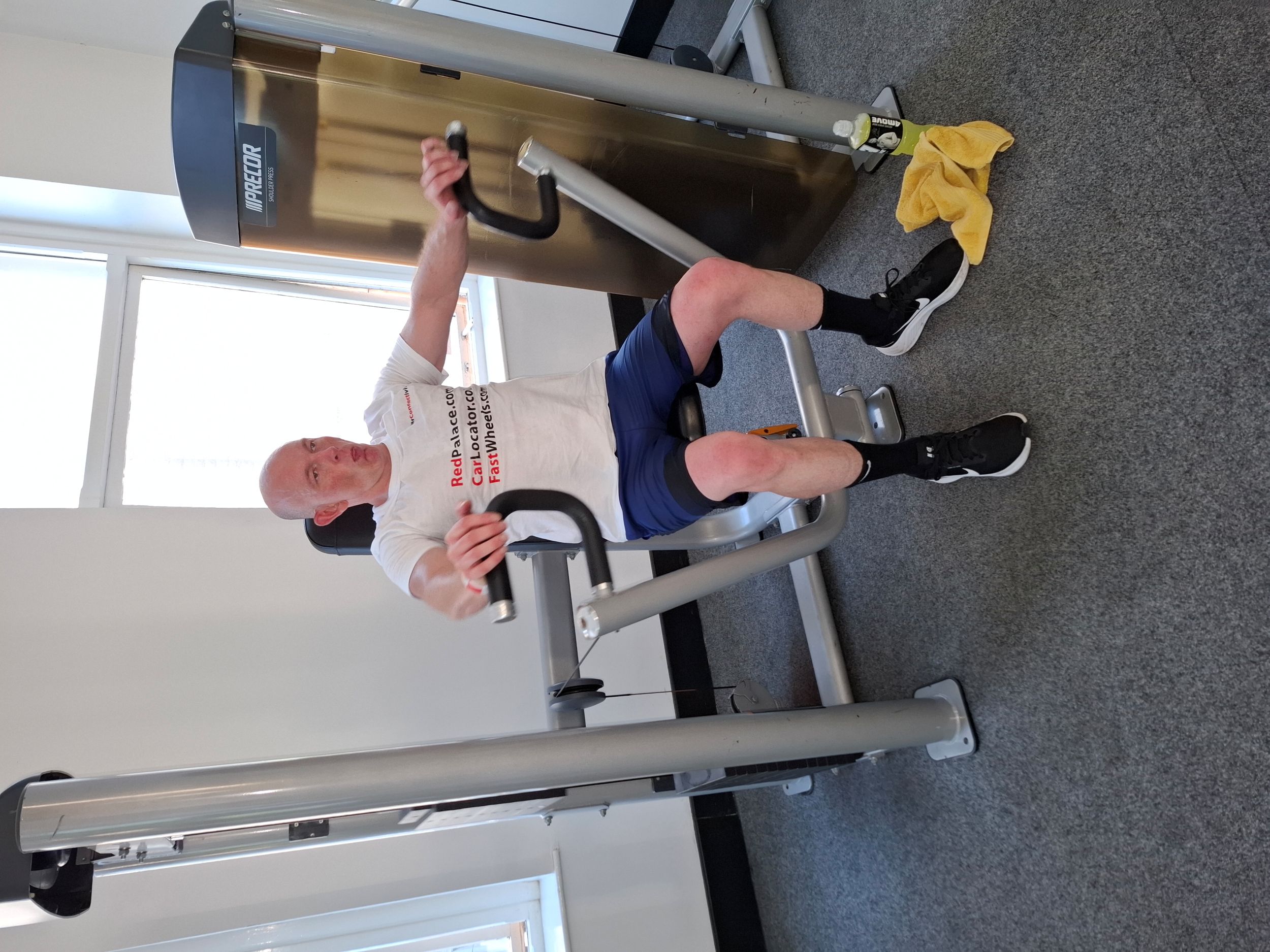 Man exercising on a chest press machine in a gym