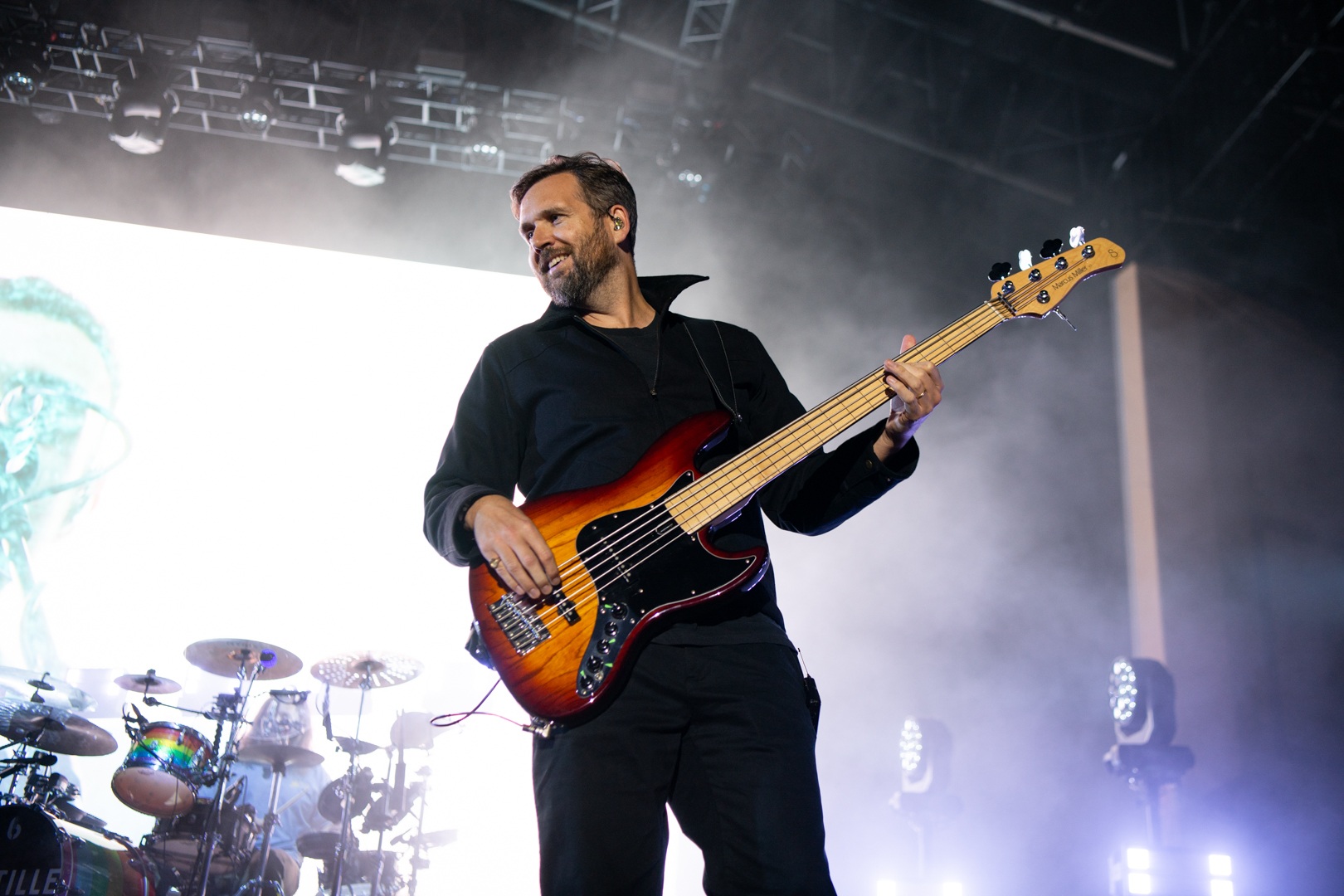 Guitarist performing energetically on stage with lighting effects