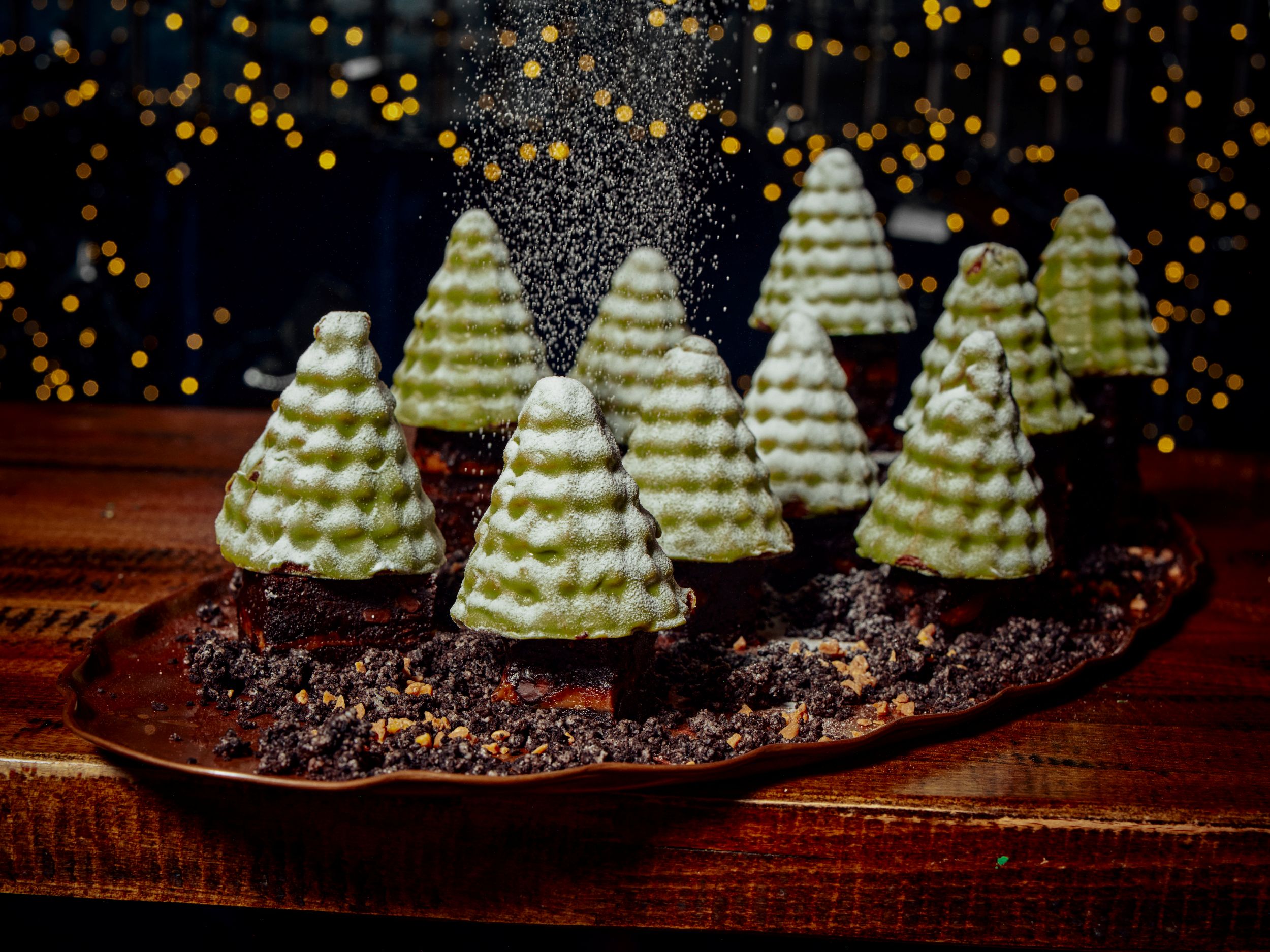 Festive chocolate and marzipan Christmas trees on a wooden table