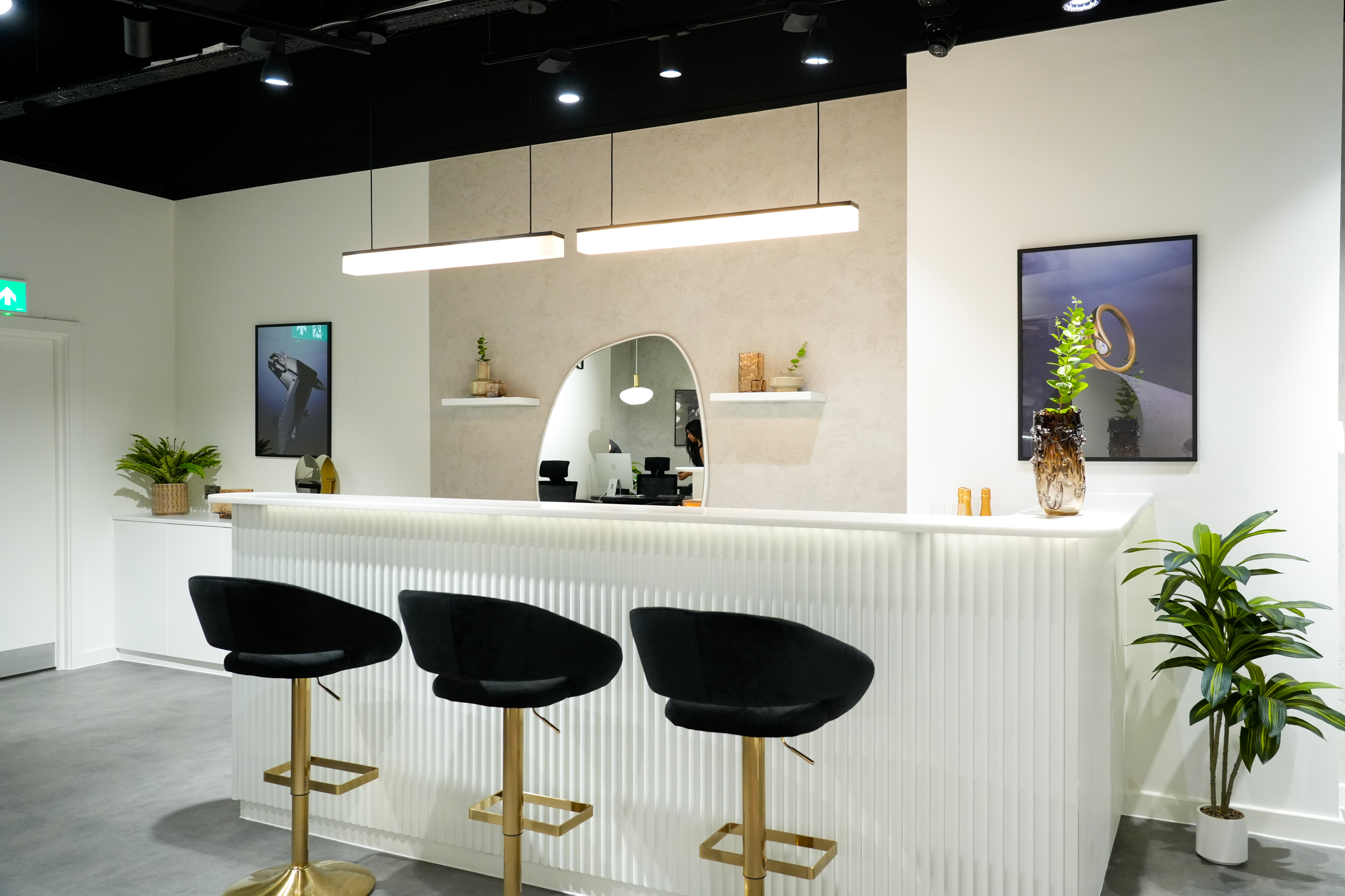 Modern reception area with sleek white counter and black chairs