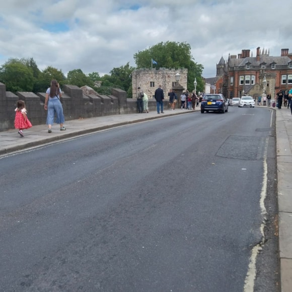 Historic stone bridge with pedestrians and cars in Yorkshire