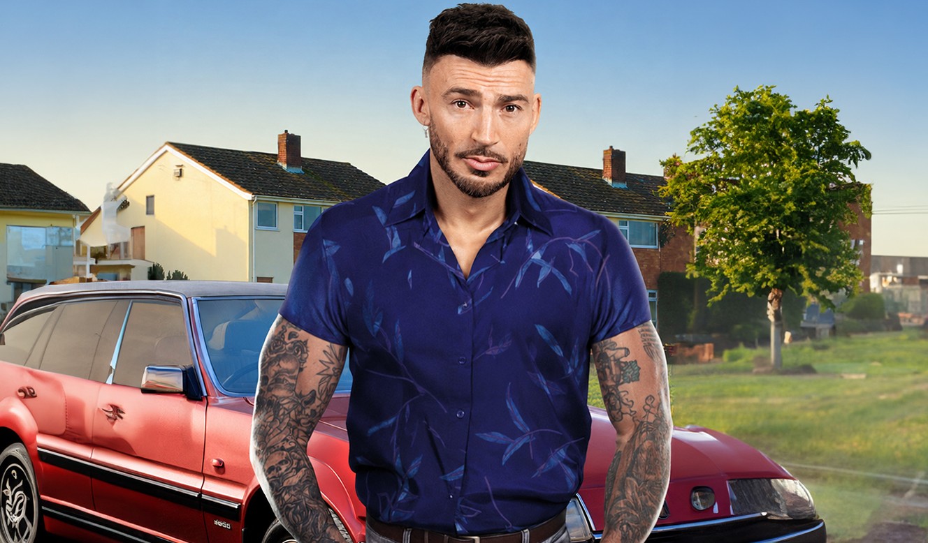 Man with tattoos in blue shirt standing by red vintage car