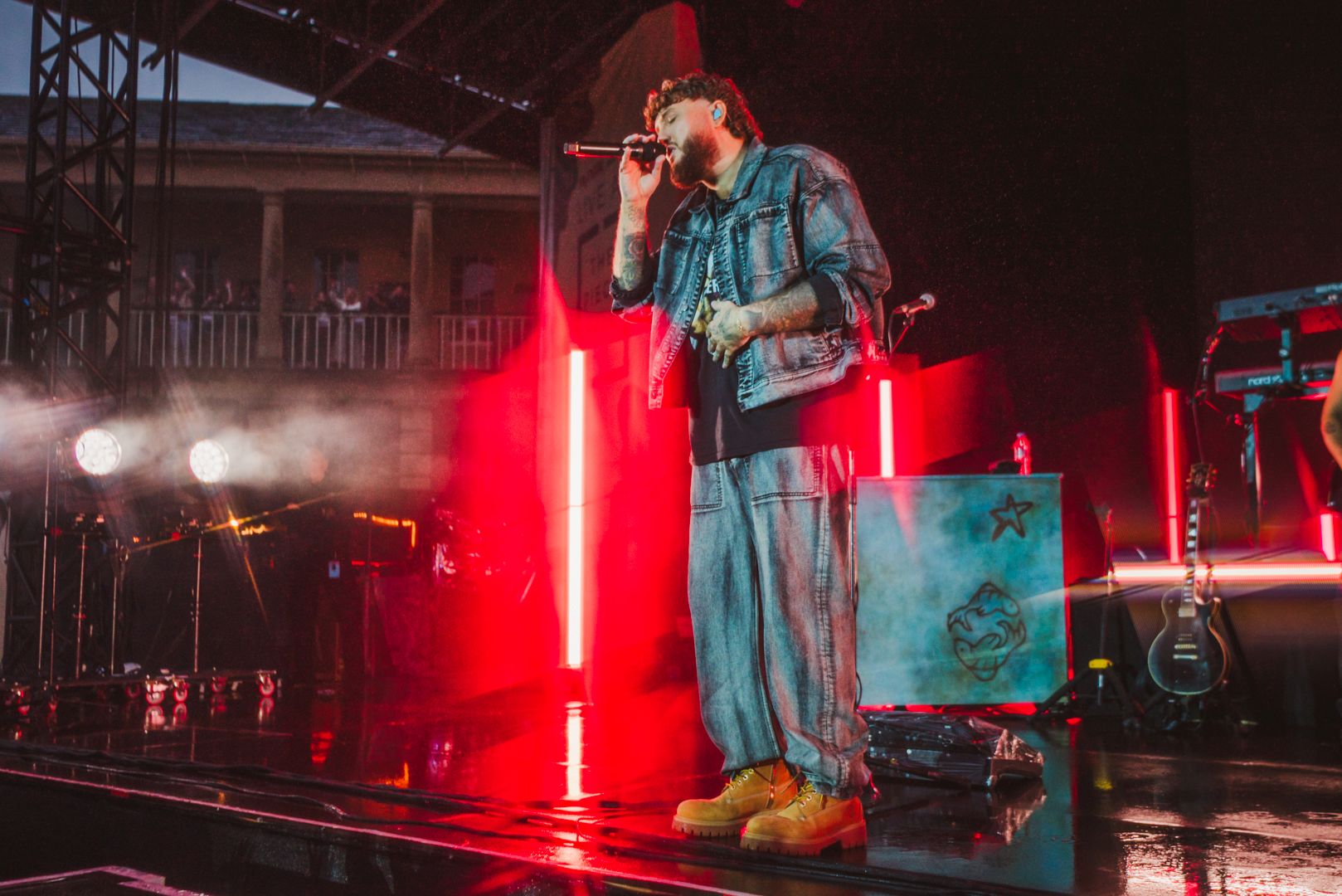 Musician performing on stage with red and blue lighting