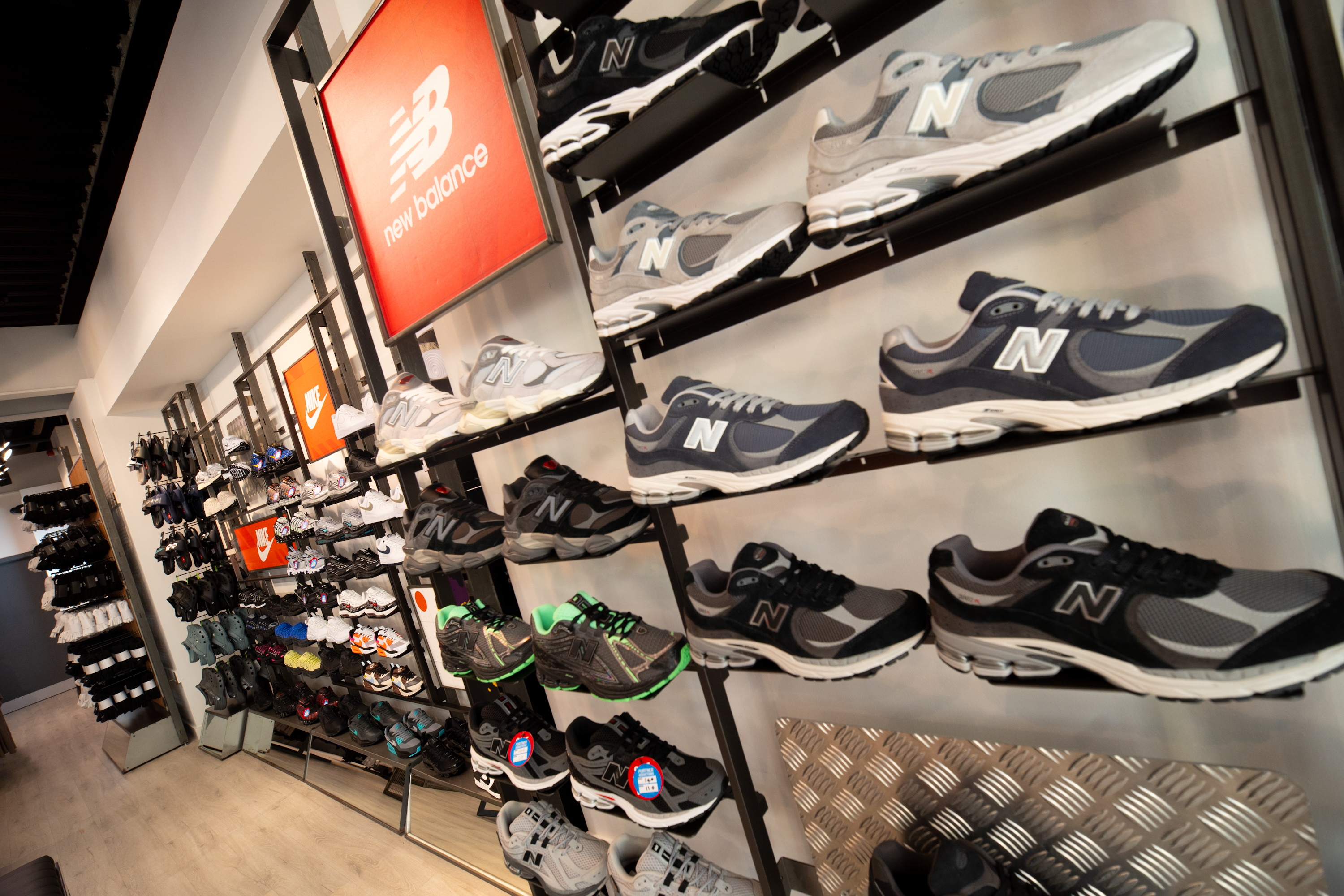 Wall display of various New Balance shoes in a store
