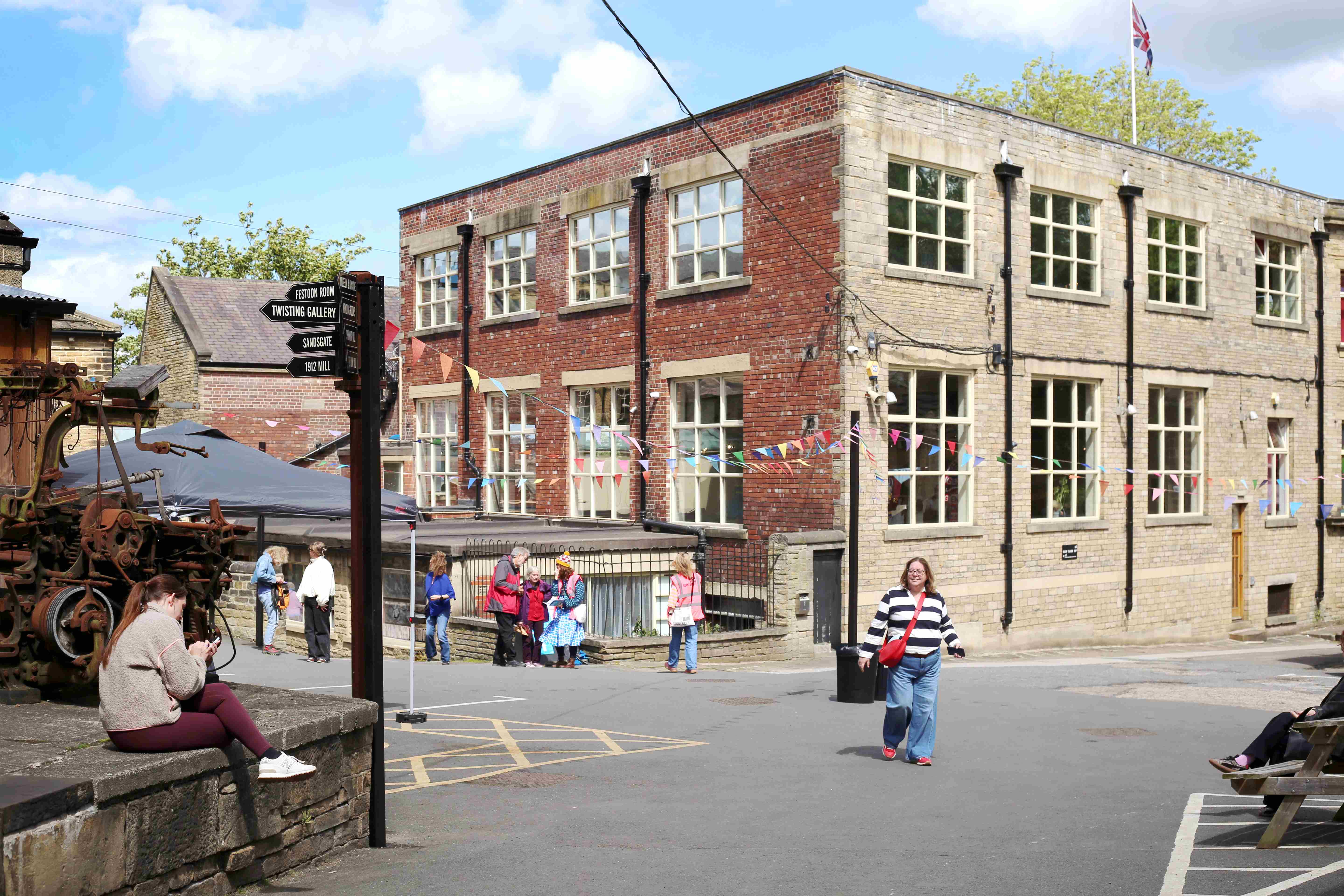 Historic stone building with colourful bunting and people outside