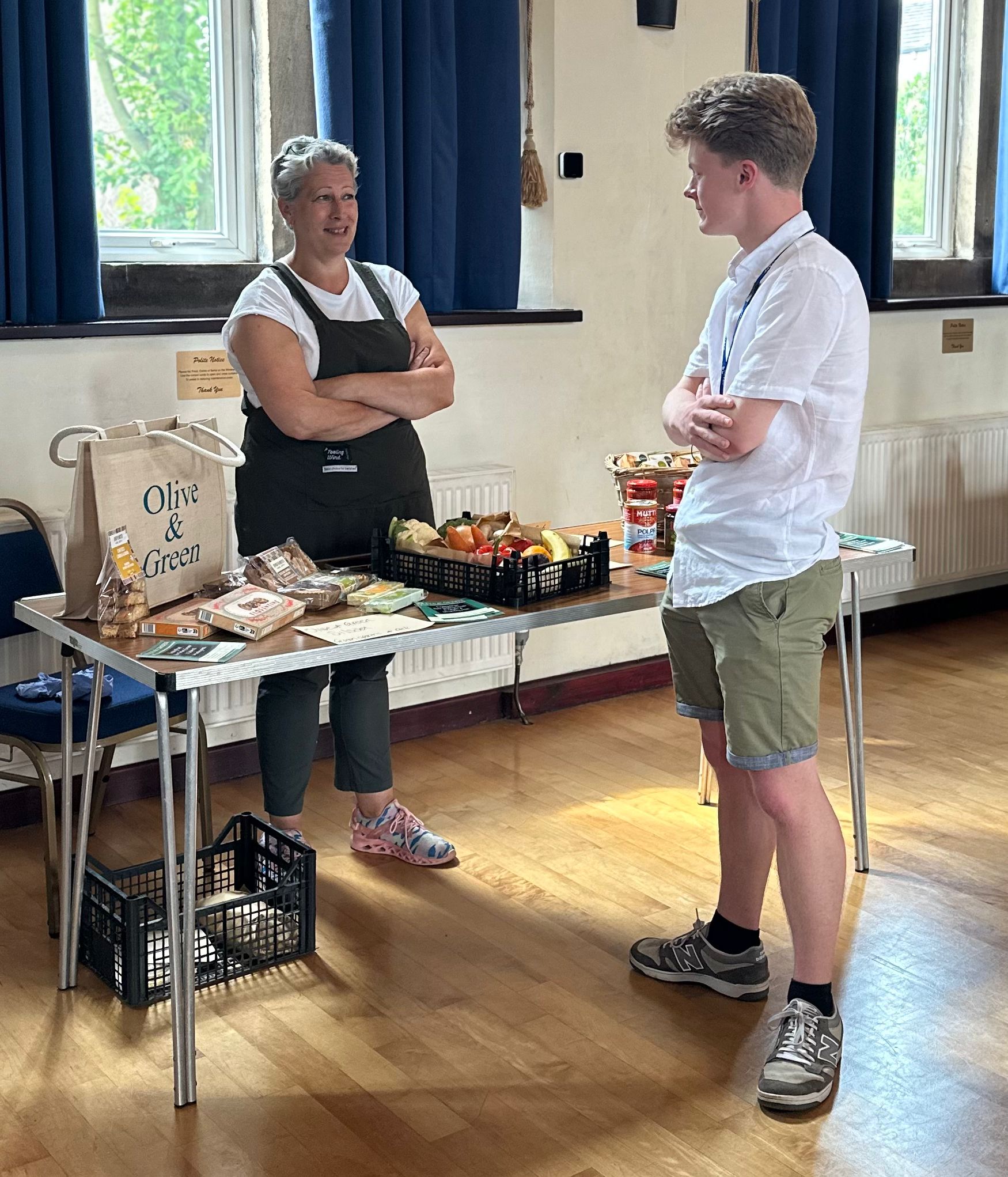 Market vendor with local produce chatting with visitor