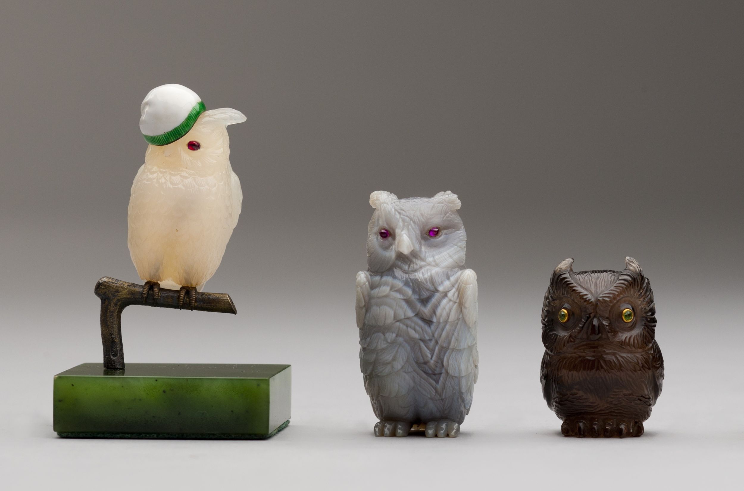 Three intricately carved owl figurines, each with unique detailing