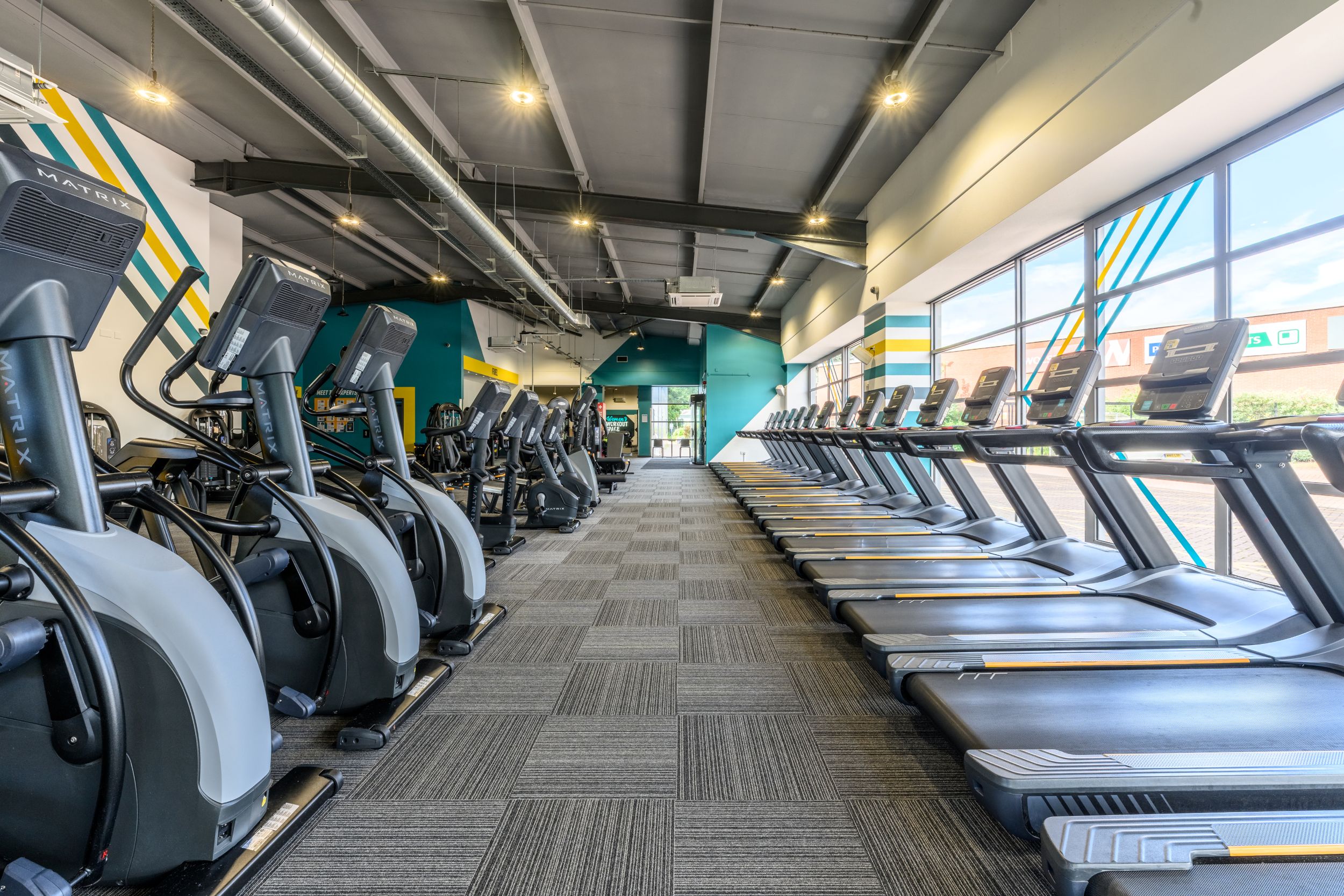 Modern gym interior with treadmills and exercise bikes