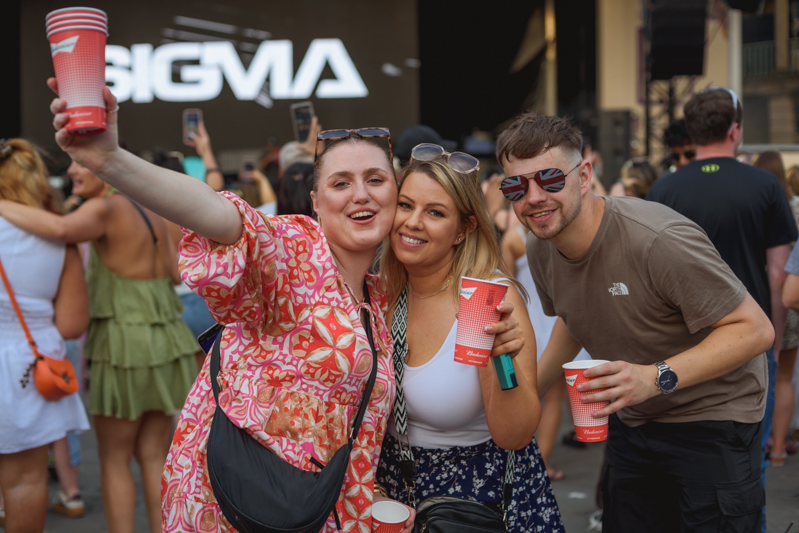 Smiling festival goers with drinks at outdoor concert - ELLIE SAXX AT THE PIECE HALL