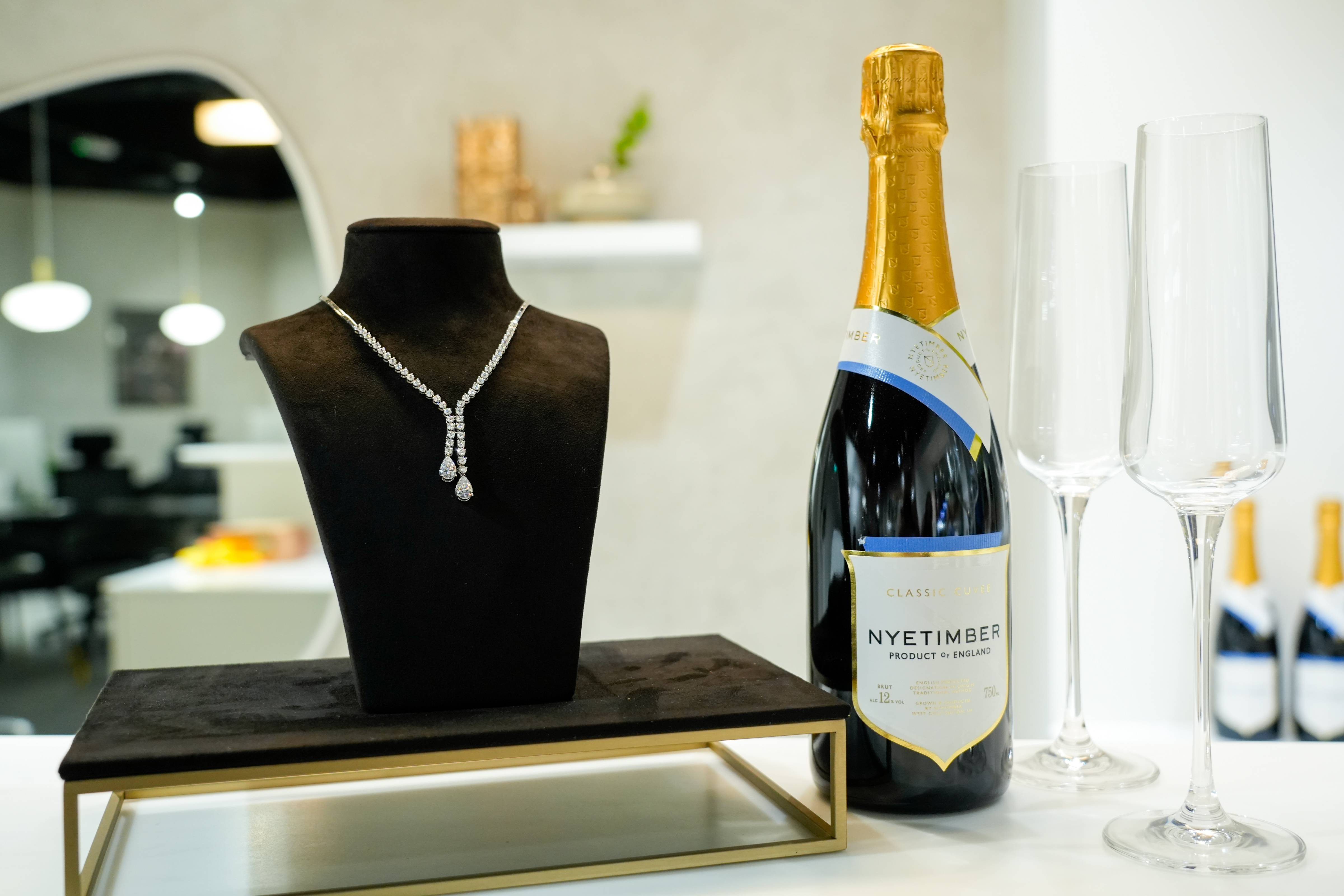 Elegant diamond necklace on display beside Nyetimber wine