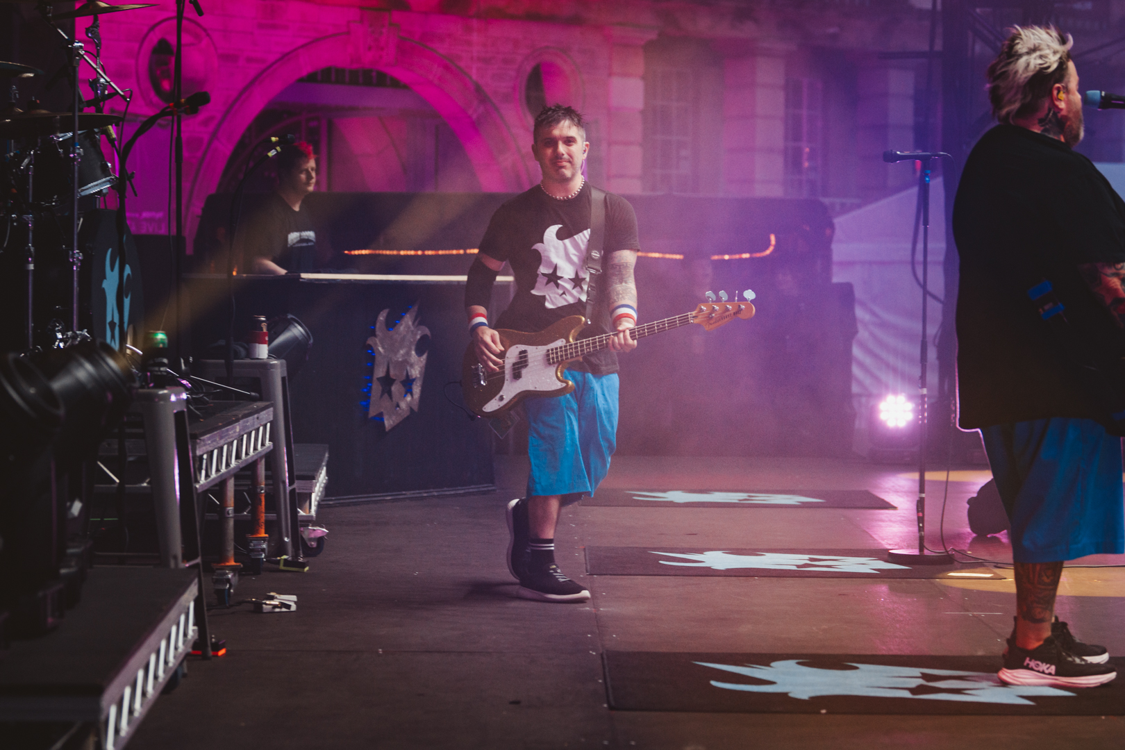 Musician with bass guitar on stage at outdoor concert