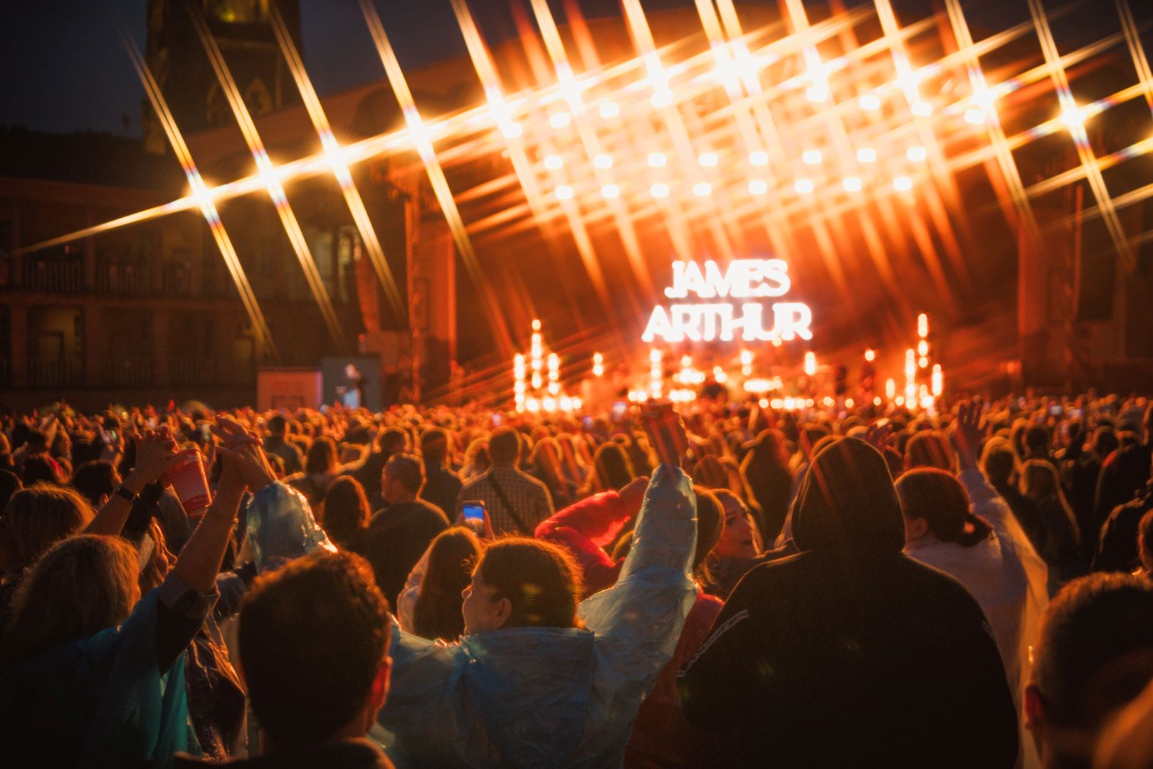 Night concert crowd under bright lights at outdoor festival