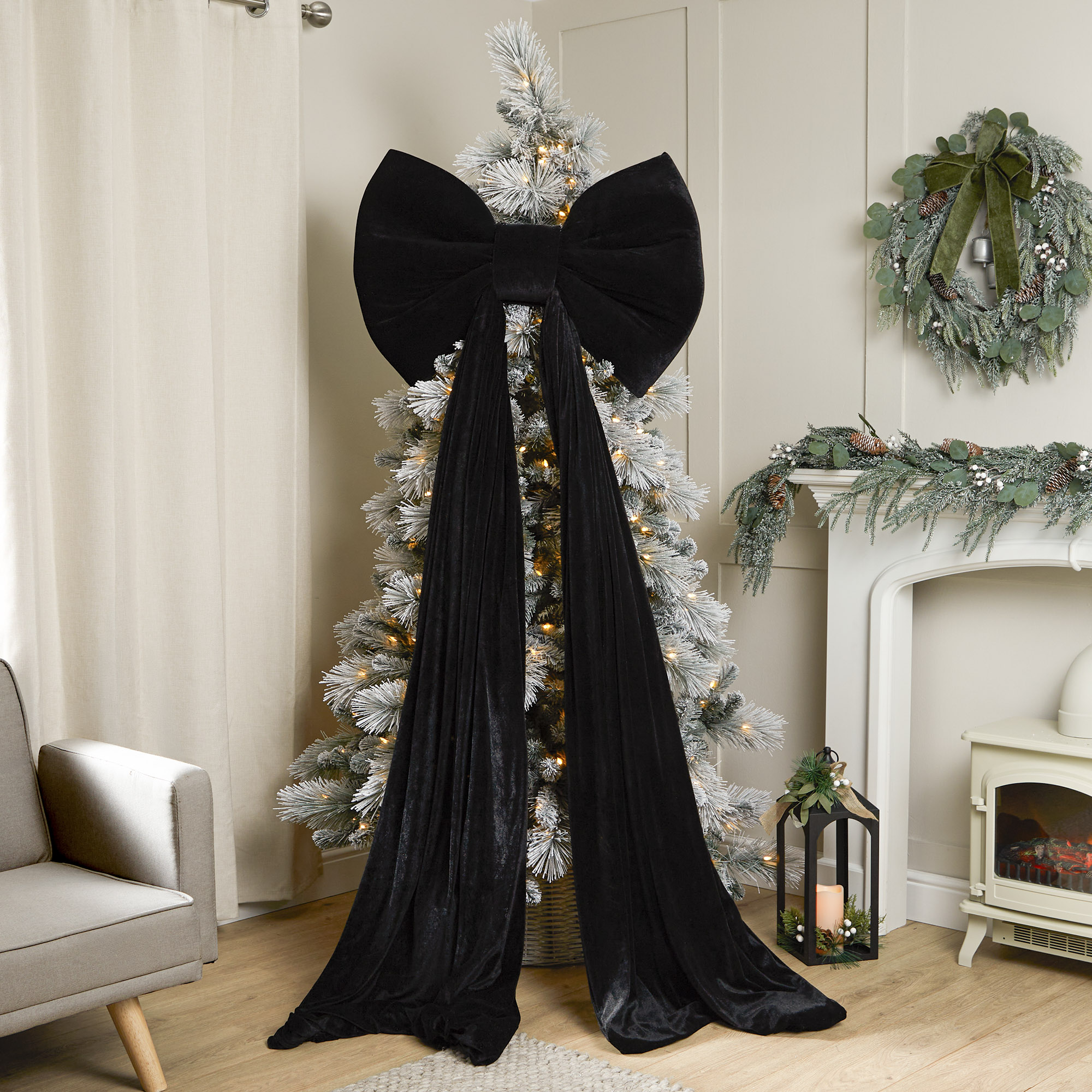 Festive living room with flocked Christmas tree and black bow