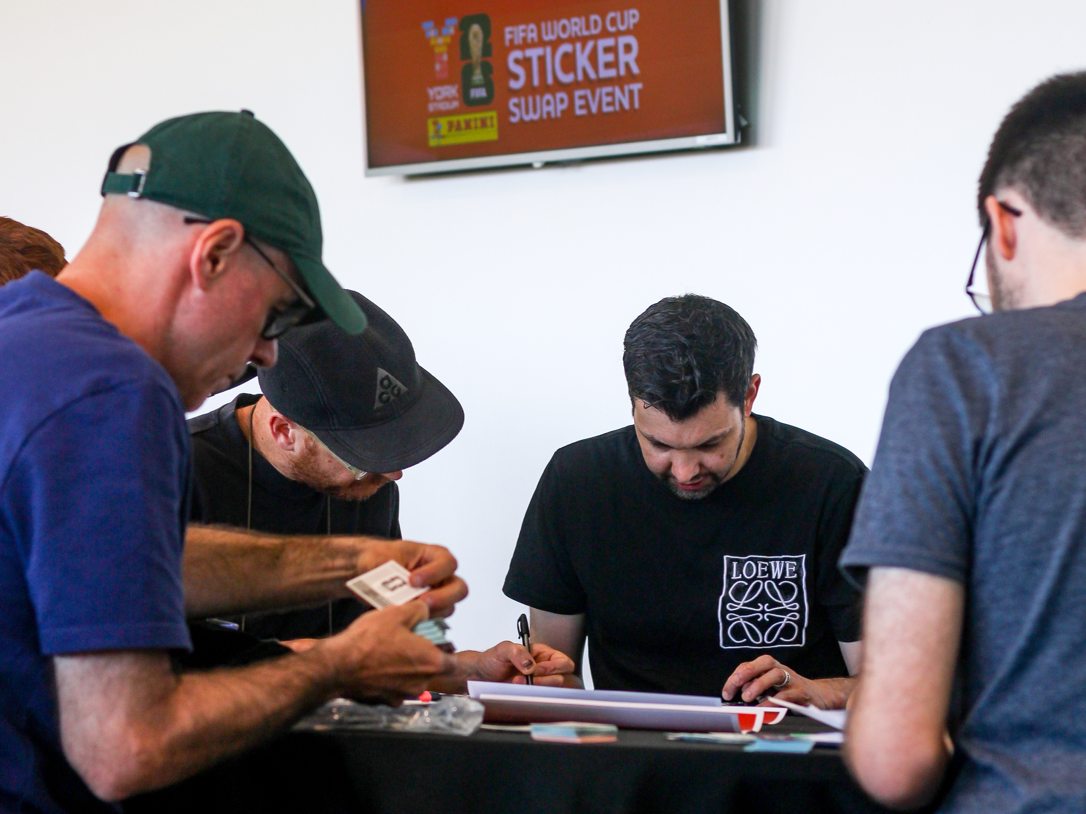 Group of people exchanging stickers at a World Cup event