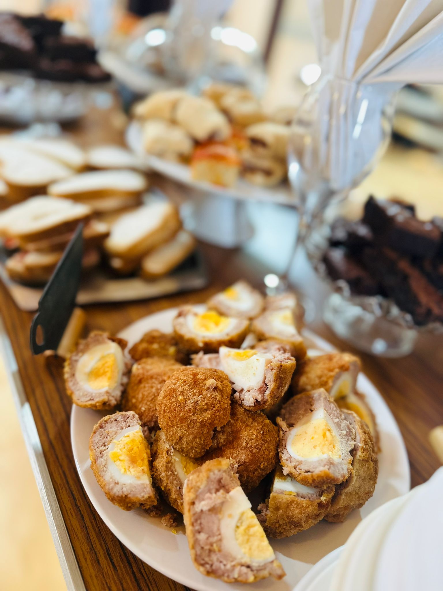 Plate of golden-brown Scotch eggs on a buffet table