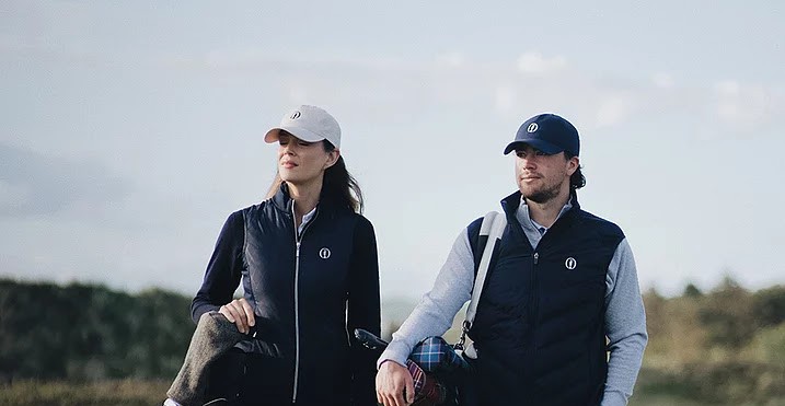 Golfers in casual attire walking on a grassy course