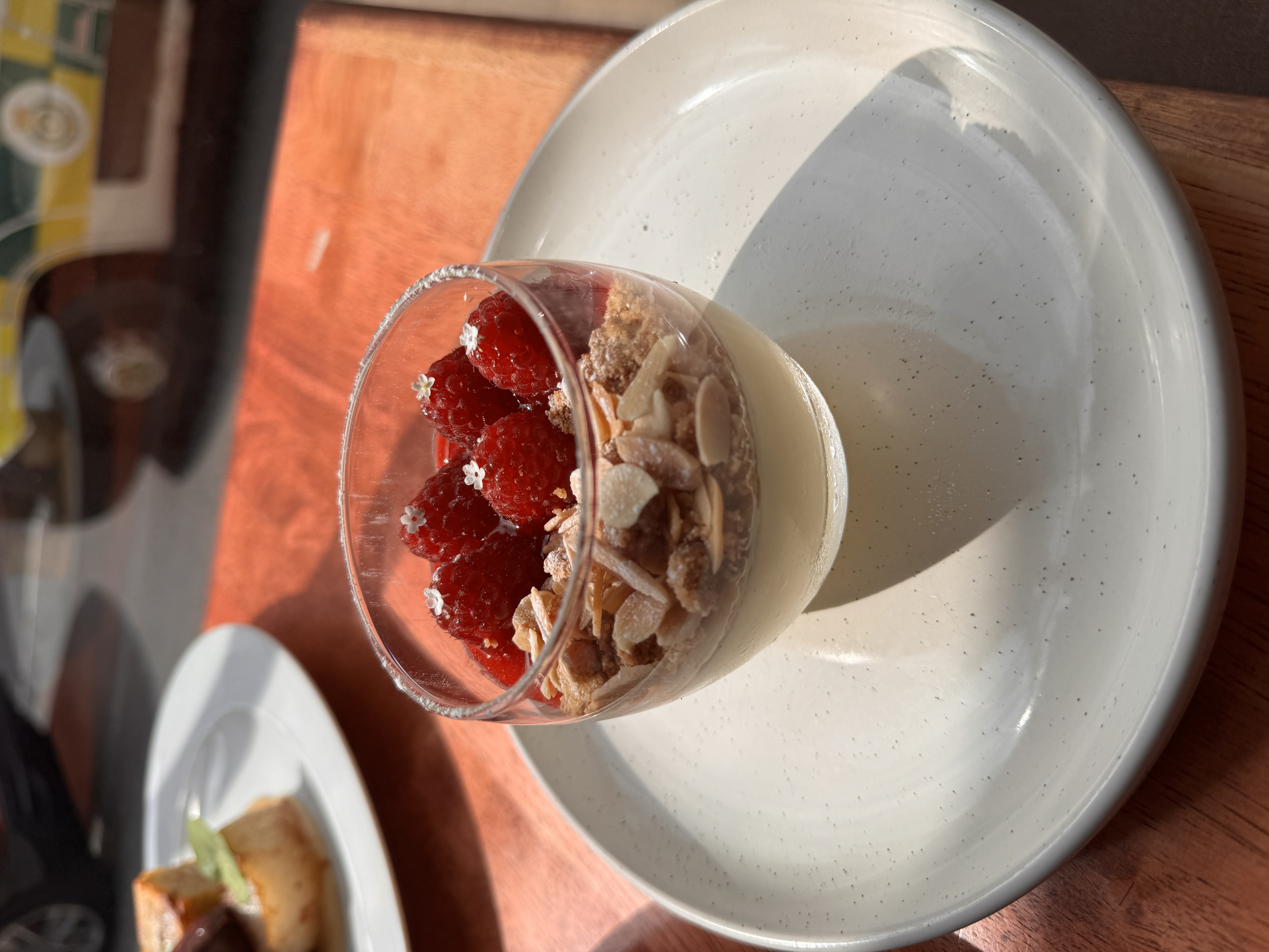 Dessert glass with creamy panna cotta, raspberries, and nuts