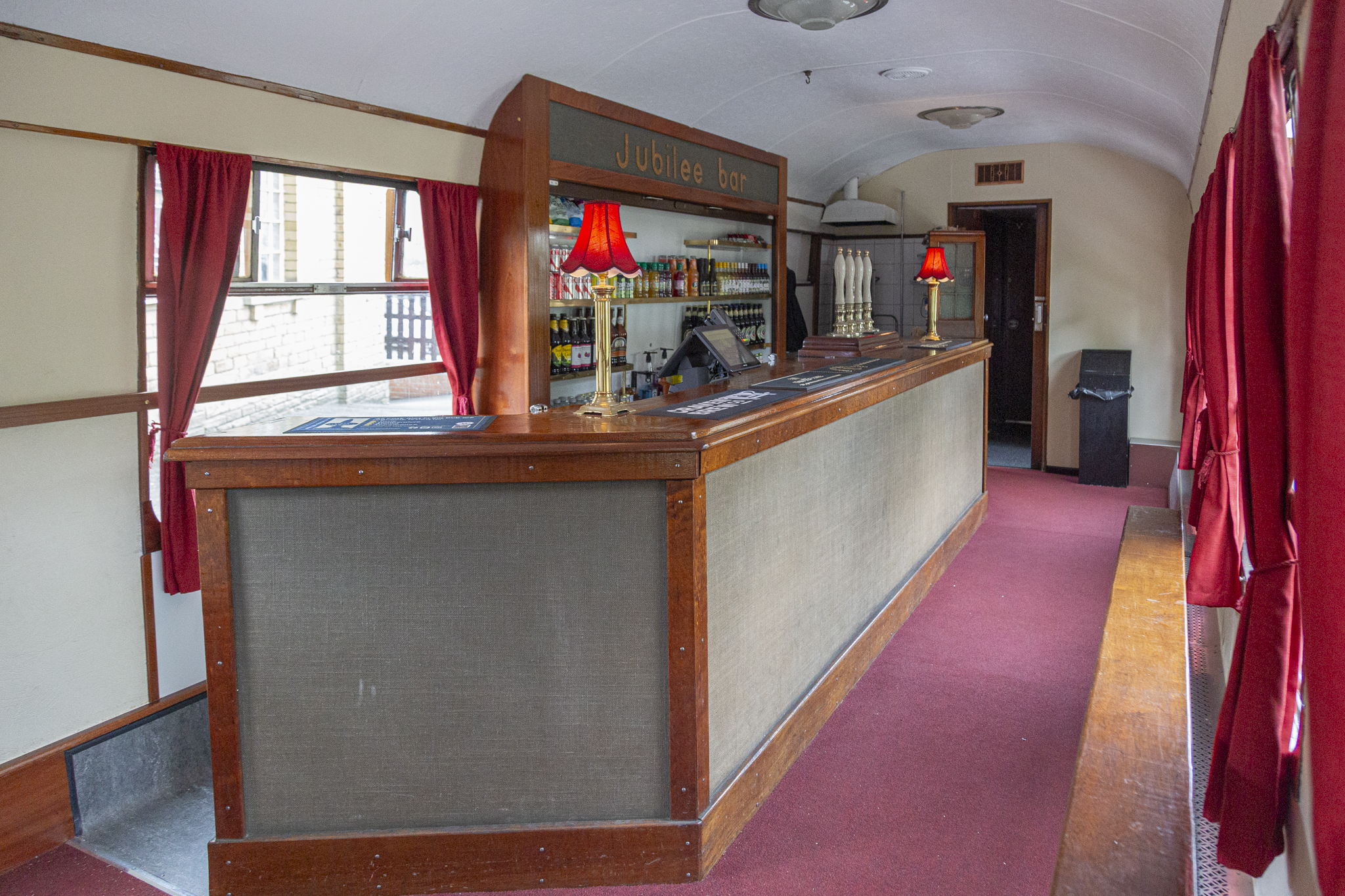 Vintage train carriage bar with red curtains and lamps