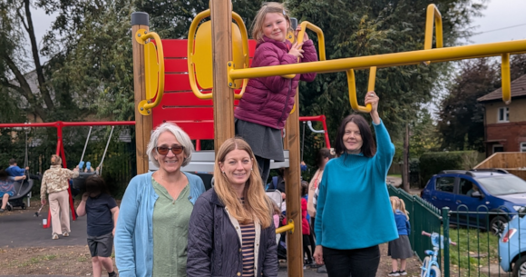 Children and adults enjoying a sunny day at a playground