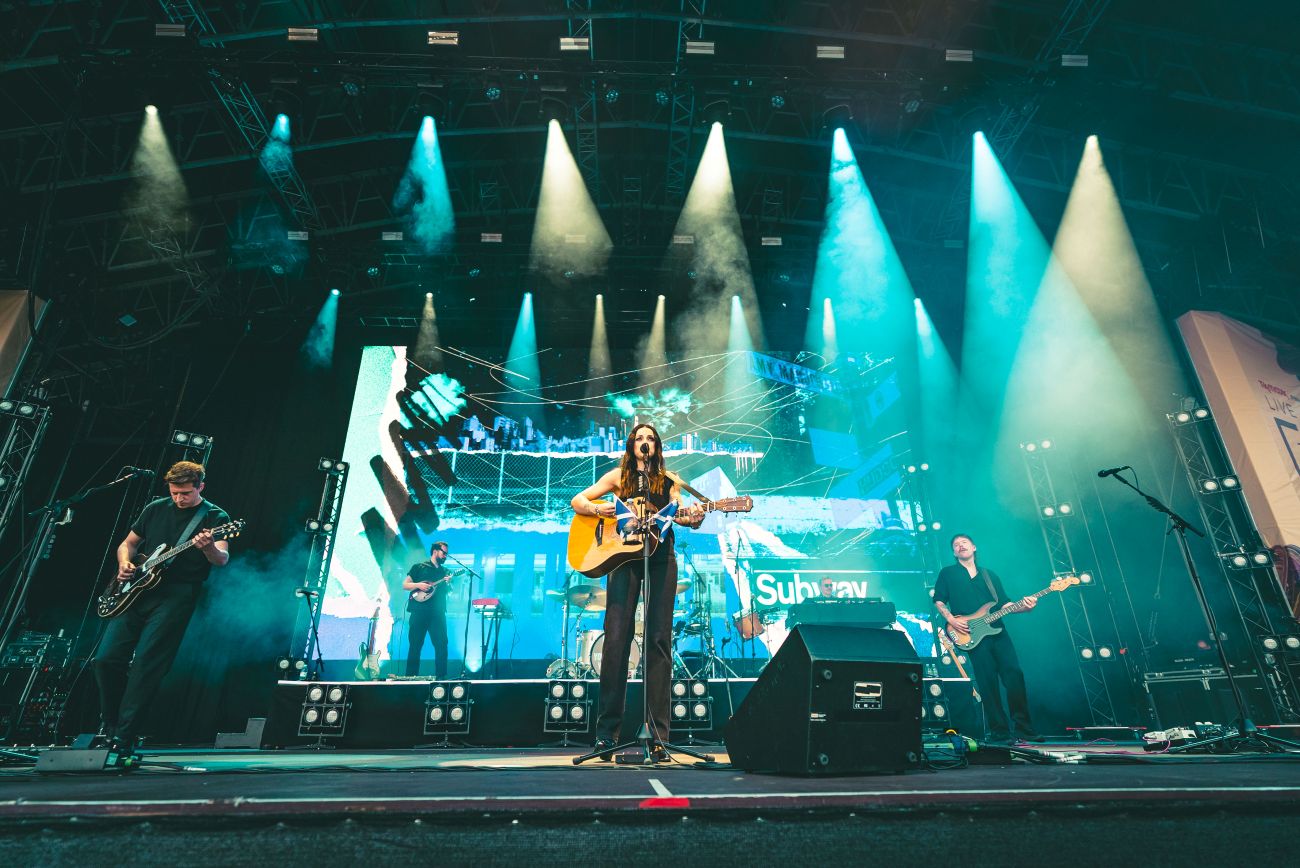 Band performing on illuminated stage at outdoor Yorkshire festival