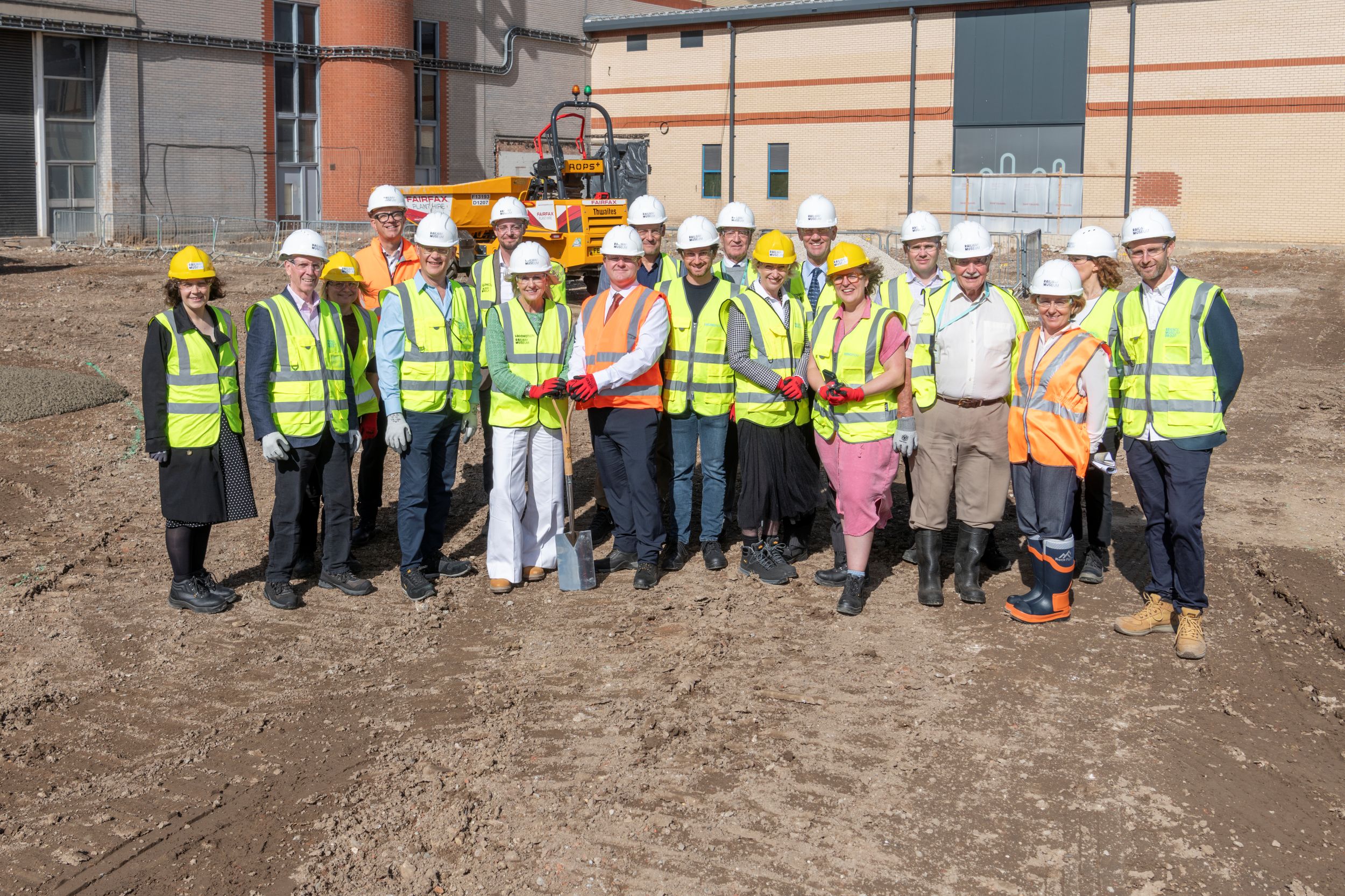 Group of construction workers in high-vis vests and hard hats on building site