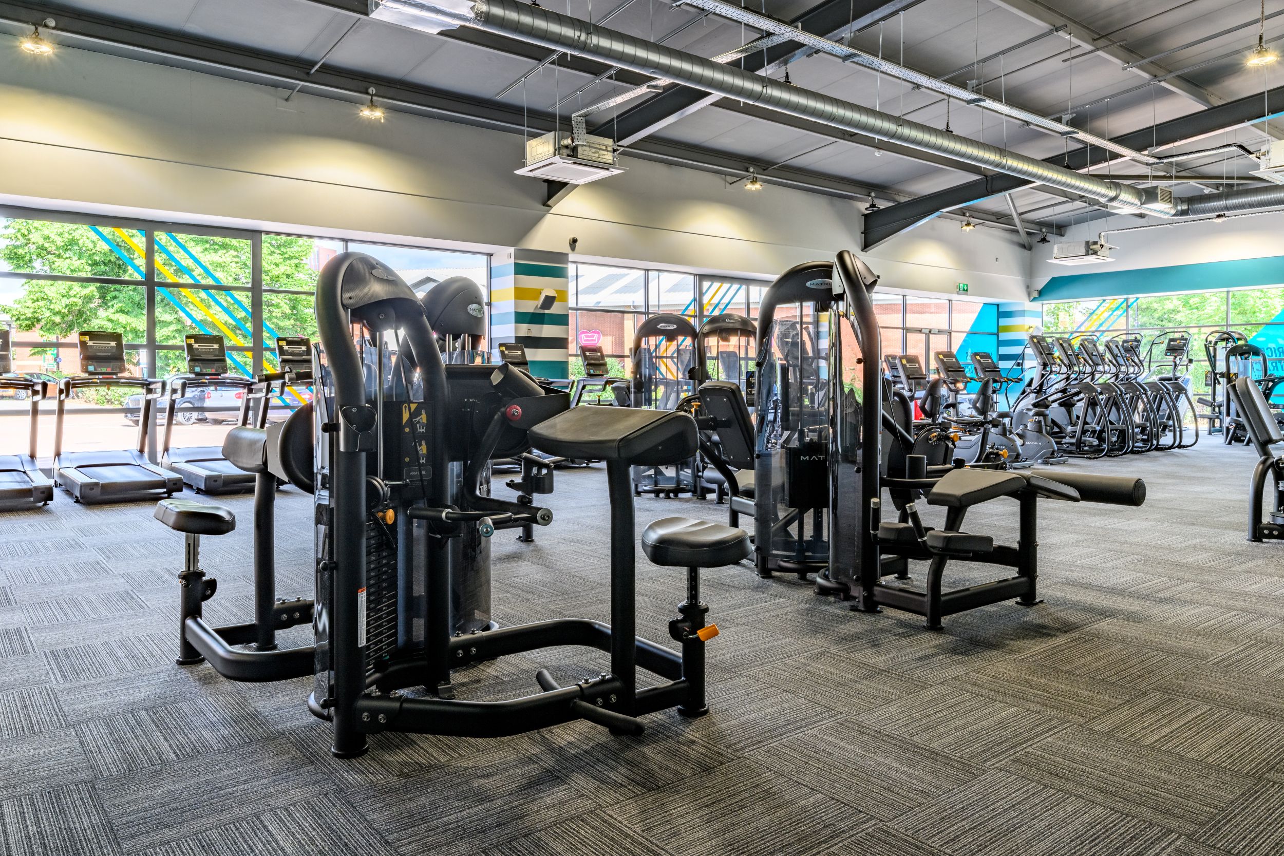 Modern gym interior with exercise machines and large windows