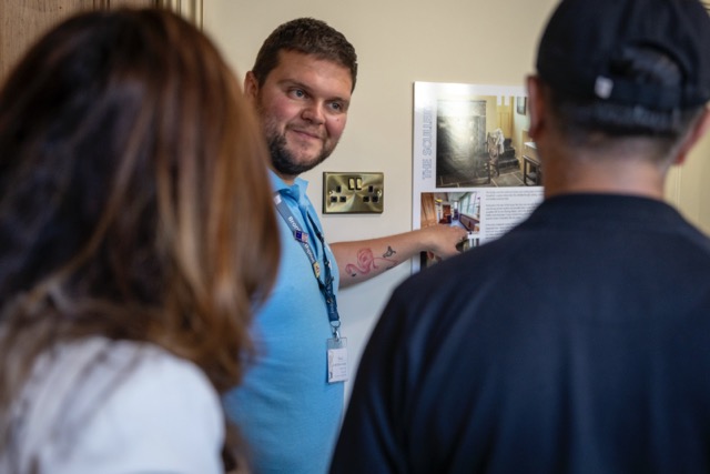 Tour guide explaining exhibit to visitors in museum