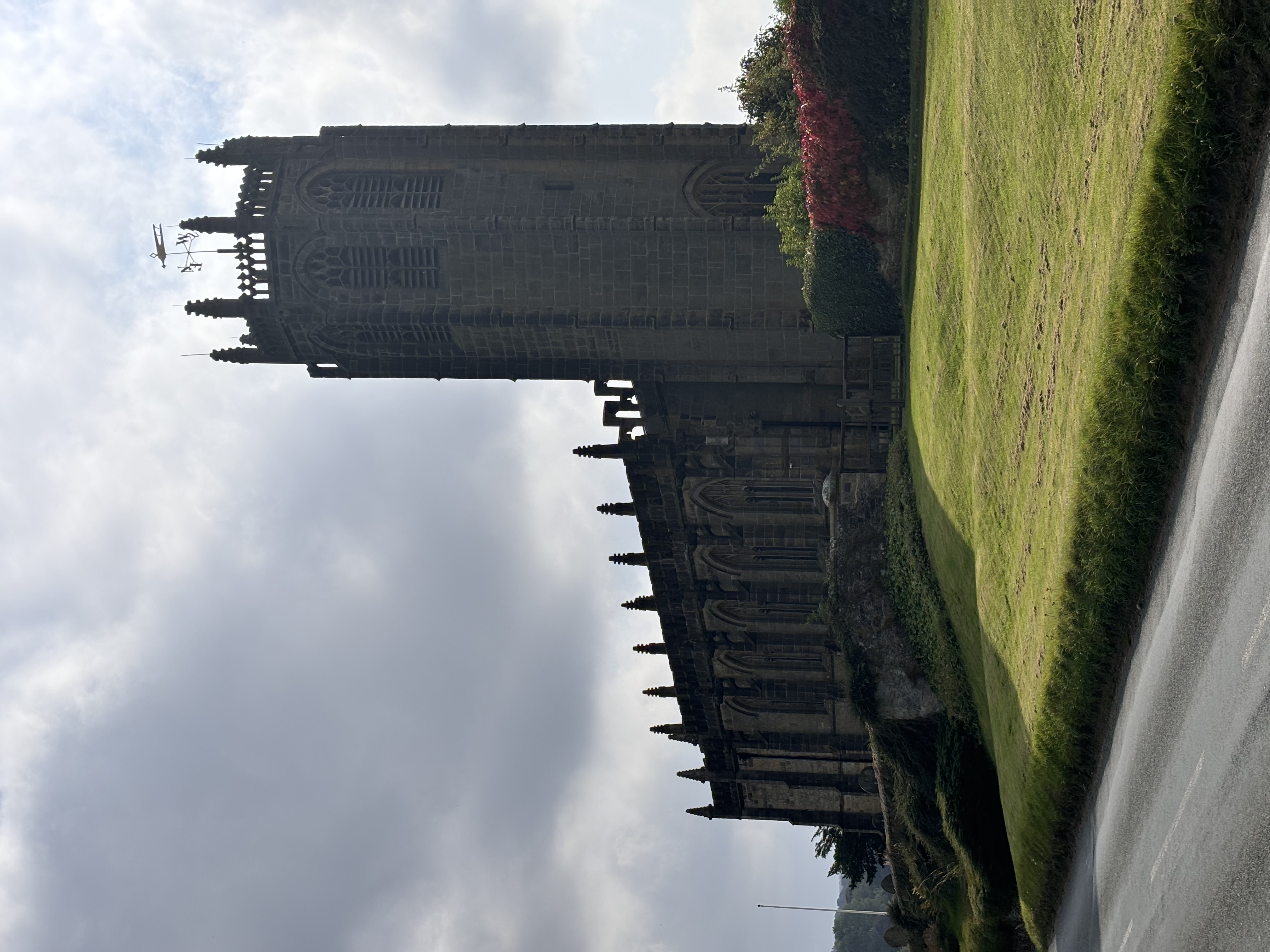 Gothic church with tall tower and stone facade under cloudy sky