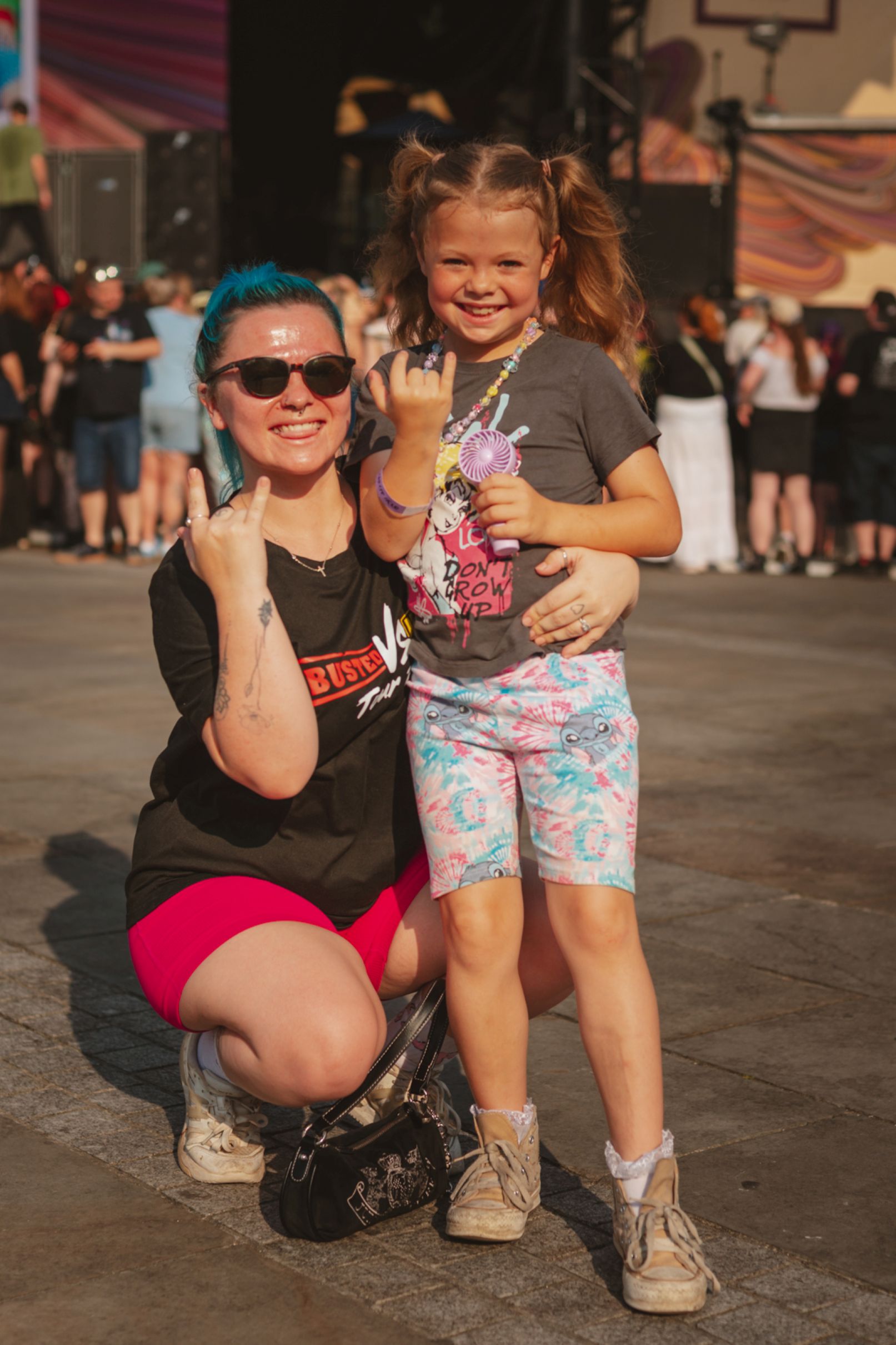 Woman and child smiling and posing at an outdoor festival