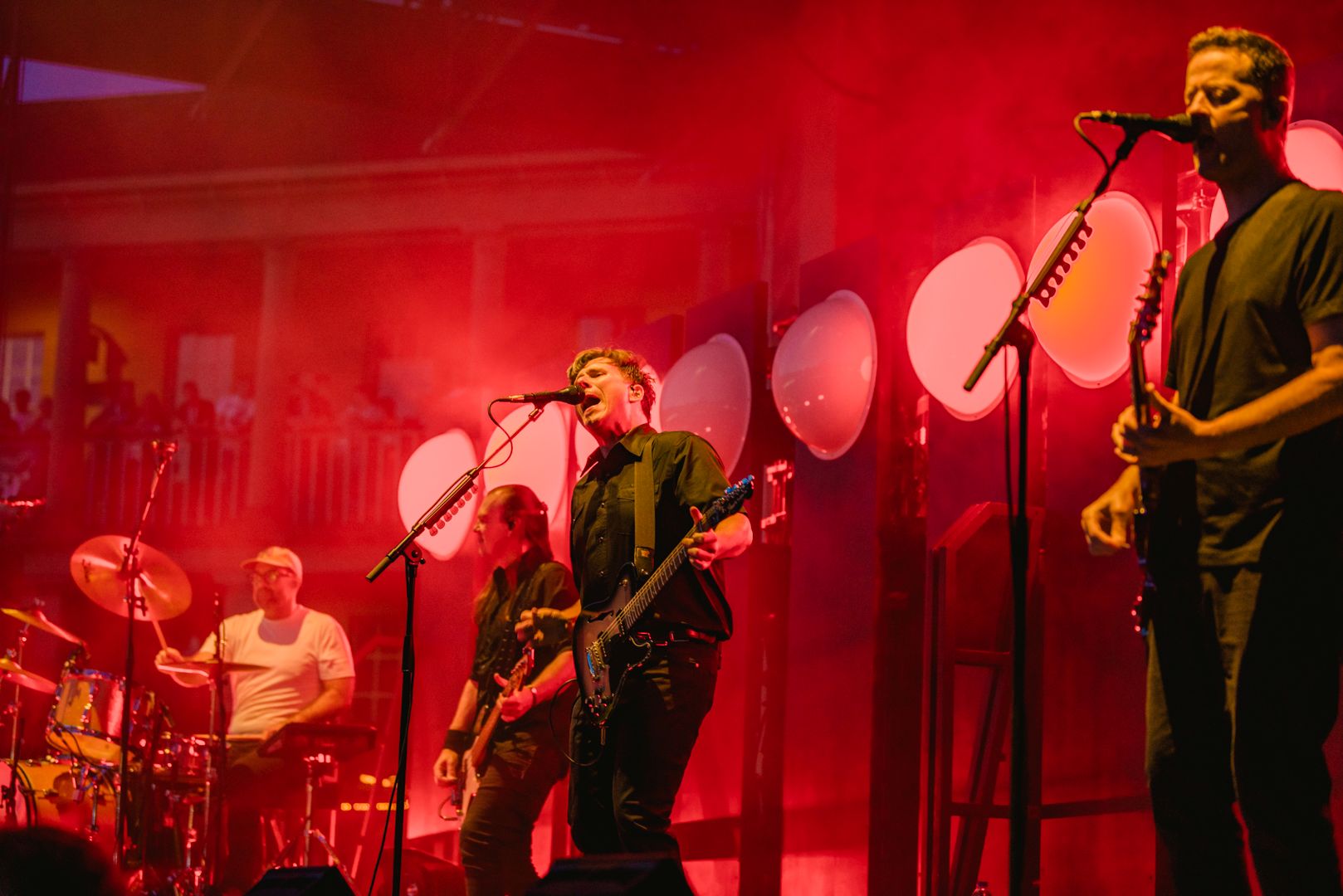 Live band performing on stage with vibrant red lighting