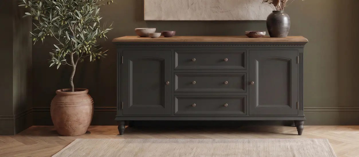 Elegant wooden sideboard with pottery and plant in vase