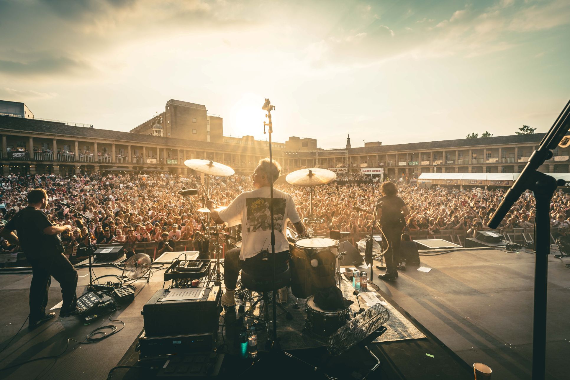 Live band performing on stage at outdoor festival with crowd