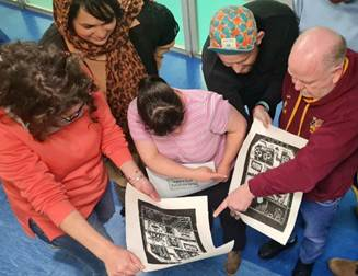 Group of people examining black and white prints in a gallery