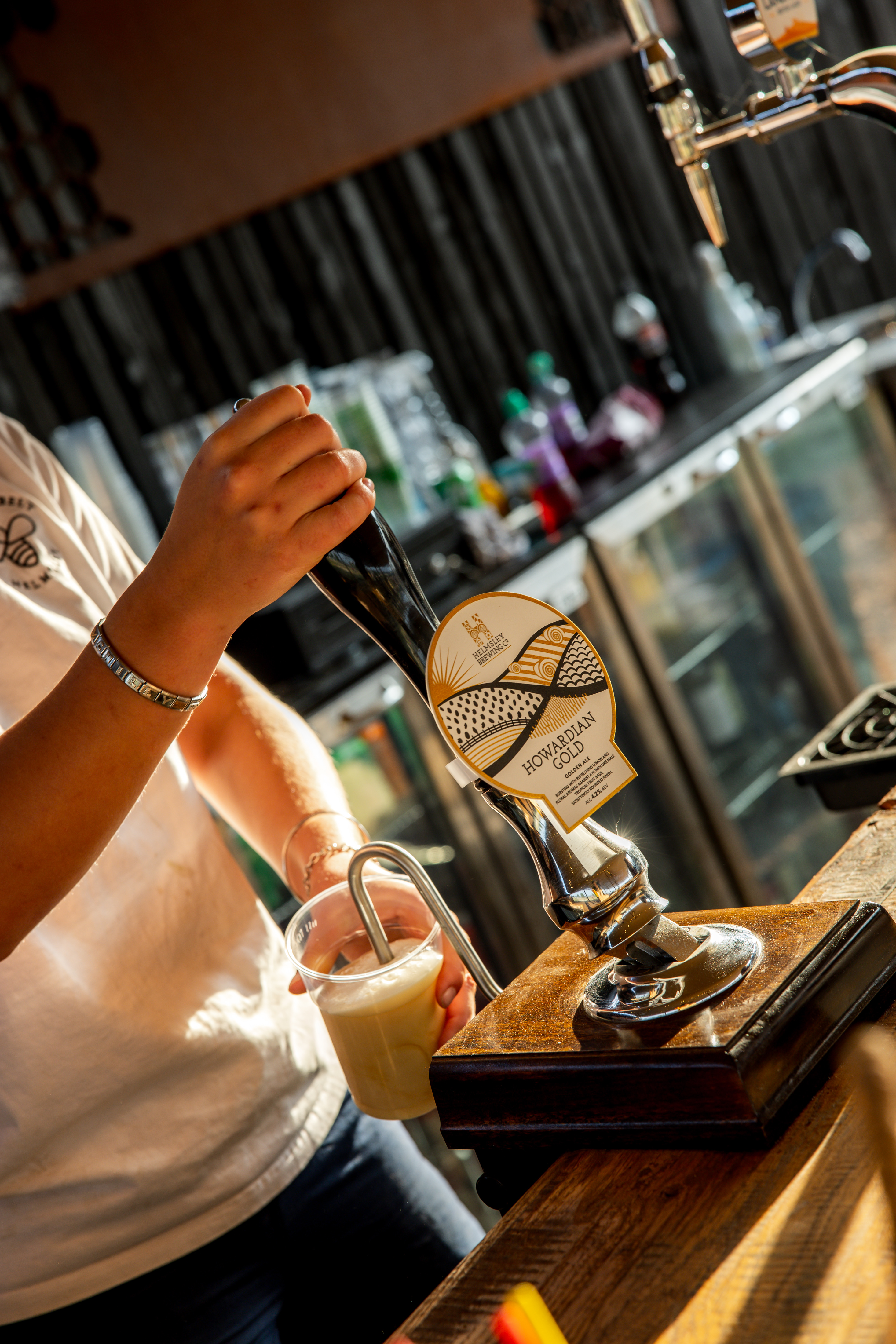 Person pouring craft beer from tap in rustic Yorkshire pub