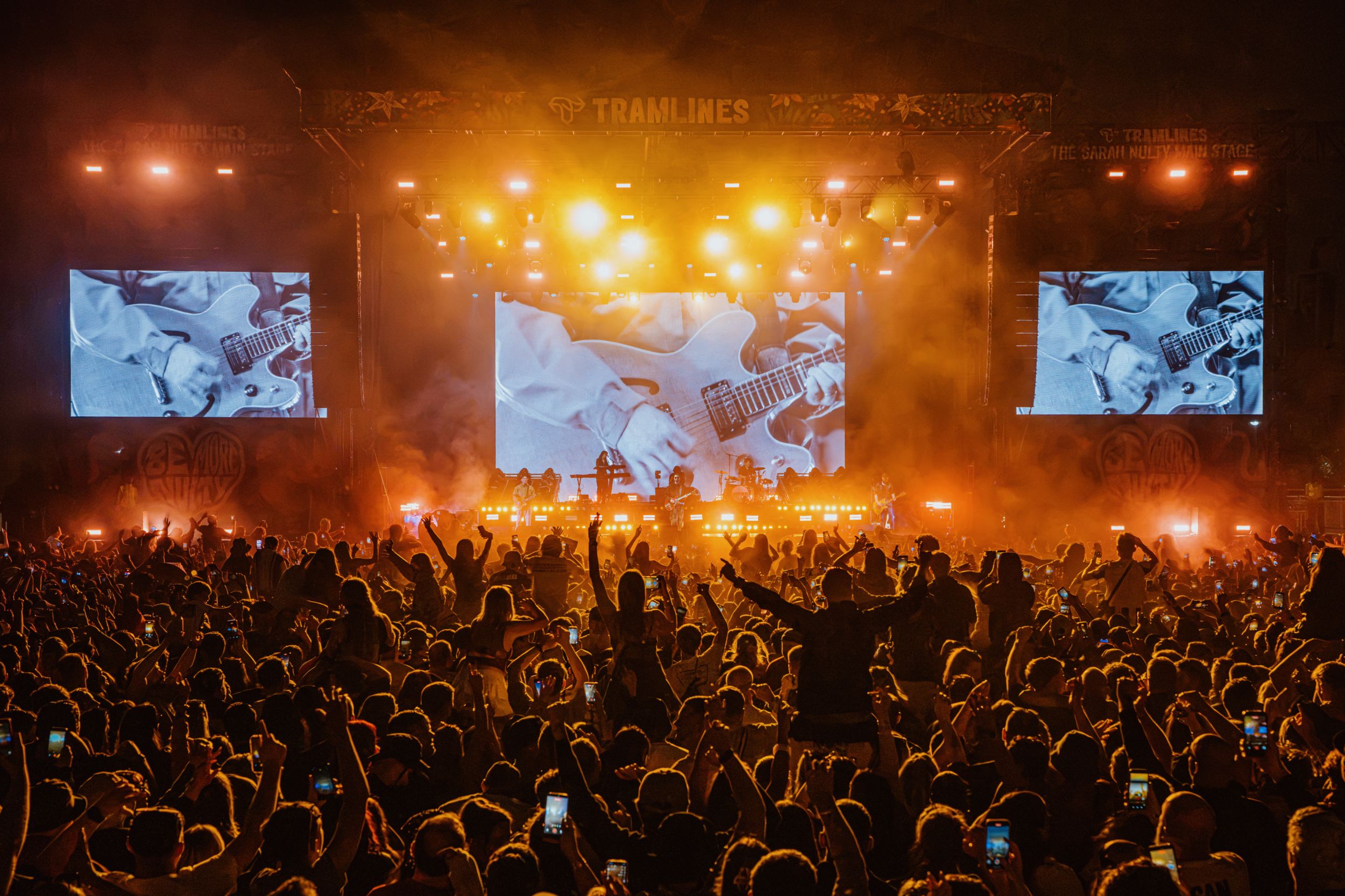 Crowd enjoying night concert with bright stage lights