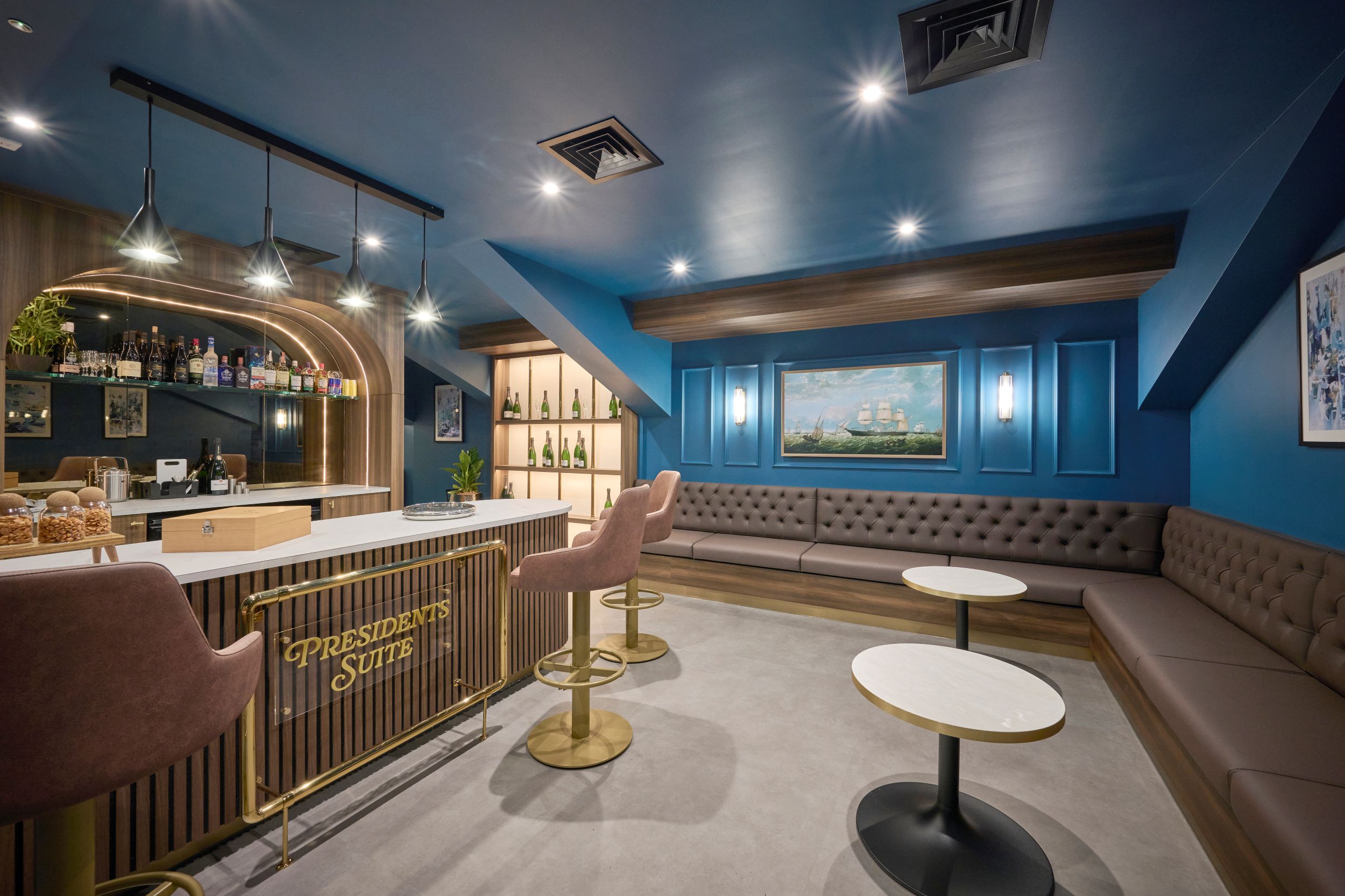 Modern hotel bar with blue walls, plush seating and artwork
