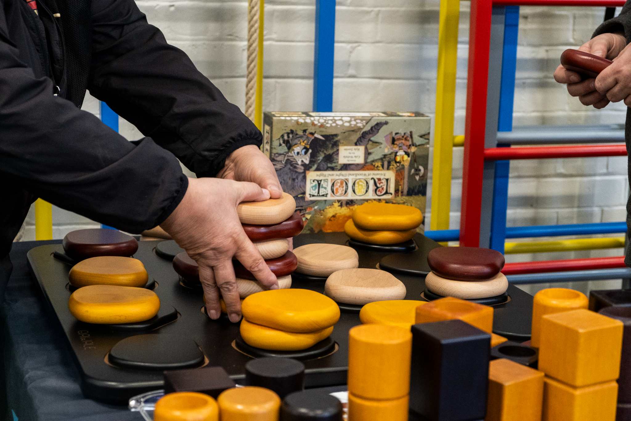 Hands arranging colourful wooden blocks in a playful setting