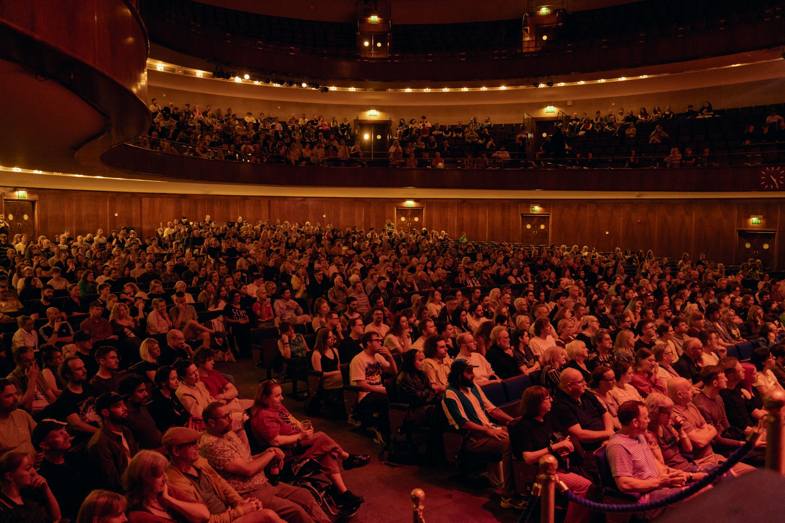 Crowded theater audience seated in a grand circular hall