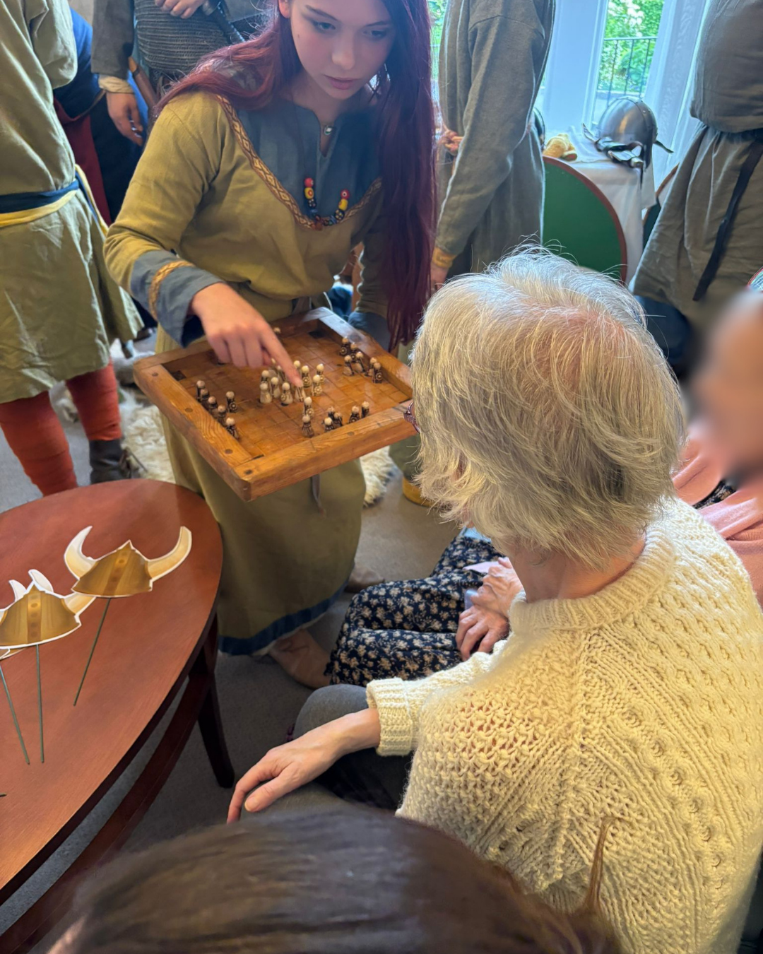 Woman in historical costume demonstrating board game